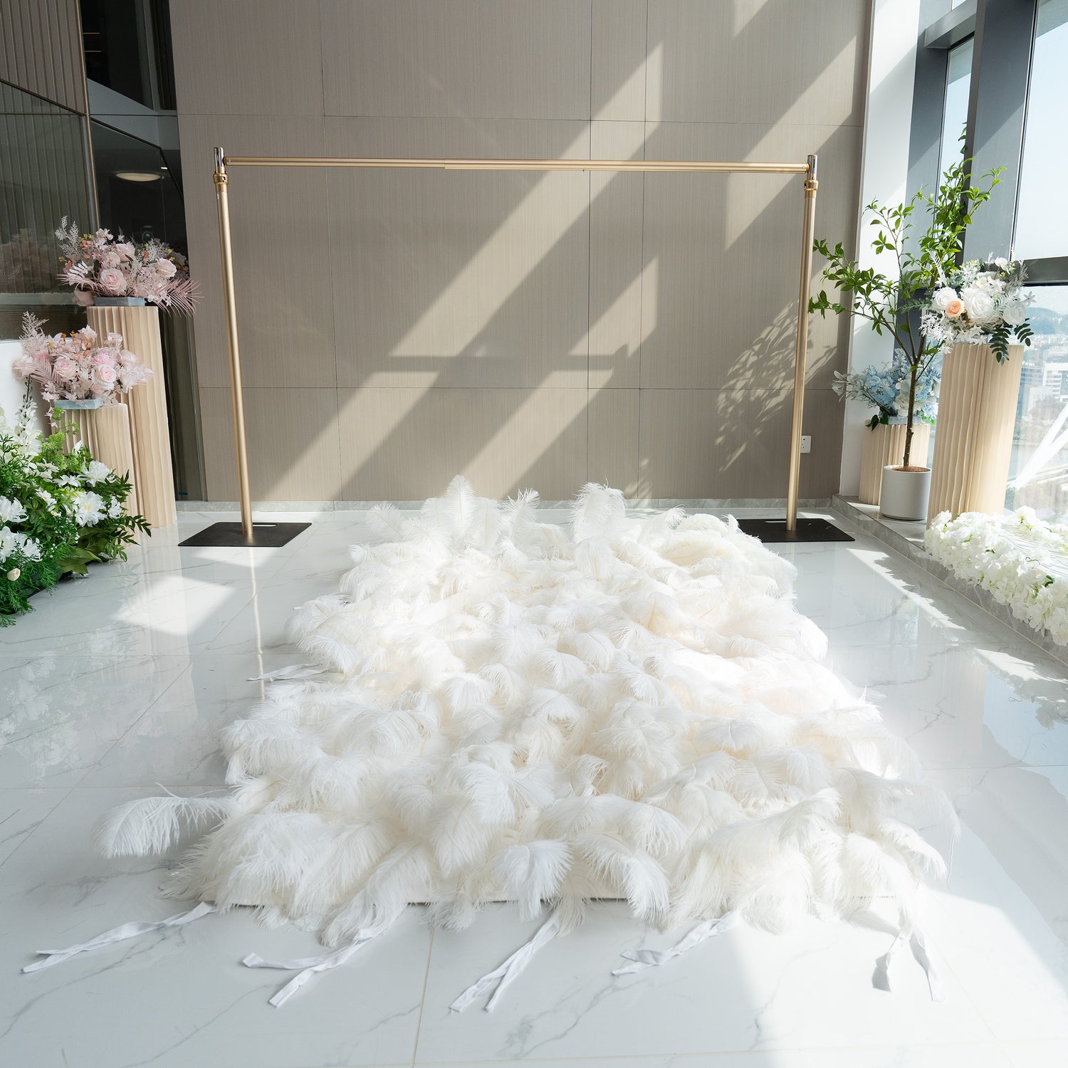 The ValarFlowers artificial feather wall is a luxurious display of white feathers. It has a soft, plush appearance, creating an elegant and dreamy backdrop, perfect for events.