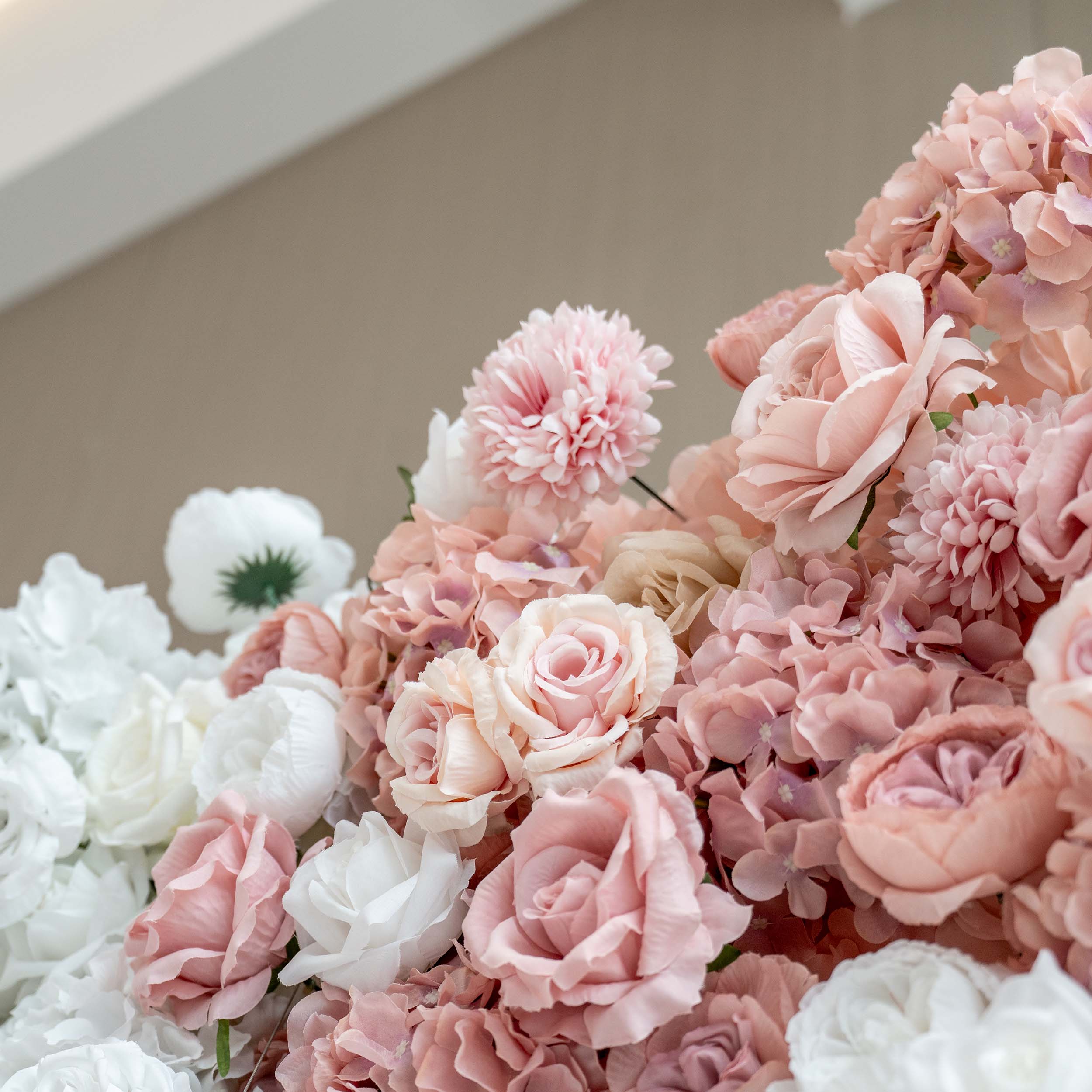 A close - up of a rich floral assembly showcases soft - pink and white artificial roses, hydrangeas, and other blooms, creating a delicate and charming display.