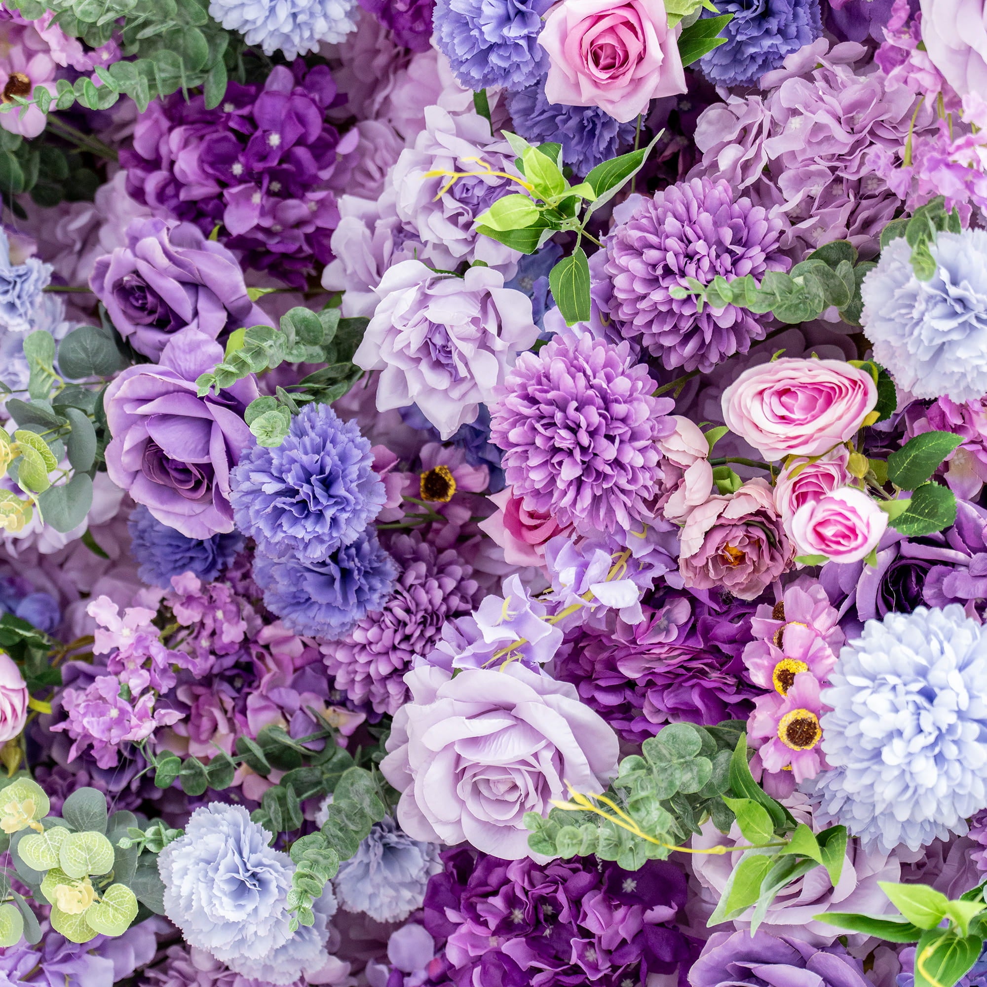 This image showcases a rich and vibrant floral arrangement predominantly in shades of purple, ranging from deep violet to light lavender, with hints of pink and blue. The flowers include roses, hydrangeas, and chrysanthemum - like blooms. There are also small, delicate flowers and green eucalyptus - like leaves interspersed throughout. The overall style is lush and romantic, creating a visually stunning and dreamy effect.