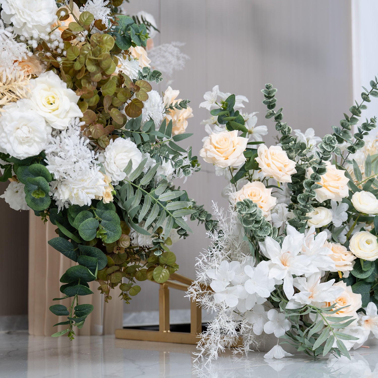 This backdrop features a luxurious floral arrangement on a golden circular structure. The flowers include white roses, creamy - hued roses, white orchids, and green eucalyptus leaves. The color palette is dominated by whites, ivories, and various shades of green. The style is elegant and sophisticated, perfect for upscale events like weddings.