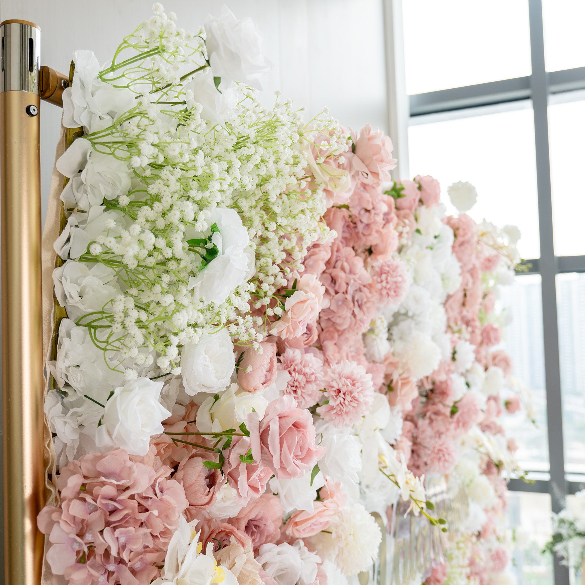 This backdrop is a lush floral arrangement supported by a golden - hued metal frame. It features a mix of artificial flowers including white roses, pink roses, white chrysanthemums, and clusters of baby&