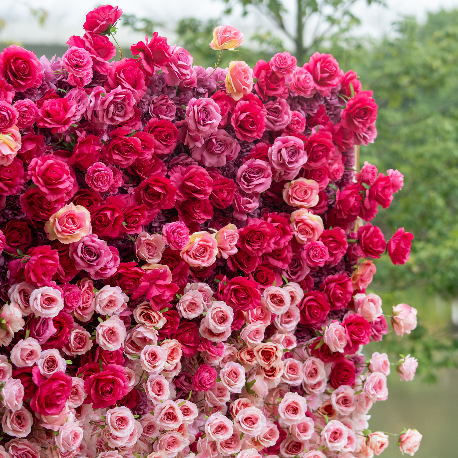 This backdrop showcases a dense, vibrant arrangement of artificial roses in a gradient of deep red to soft pink. The lush, tightly - packed blooms create a luxurious, romantic atmosphere, ideal for weddings or upscale events.