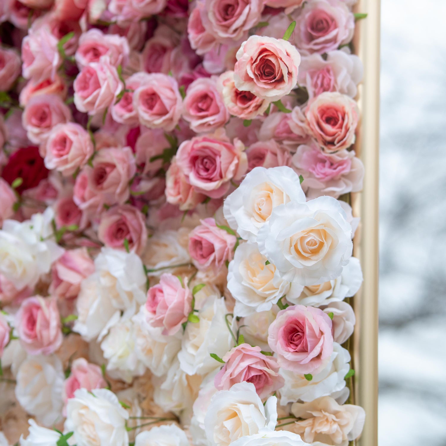 This backdrop features a dense, beautiful arrangement of artificial roses in soft pink and white hues. The roses are meticulously placed, creating a gentle color gradient that exudes a romantic and elegant ambiance, ideal for weddings or special events.