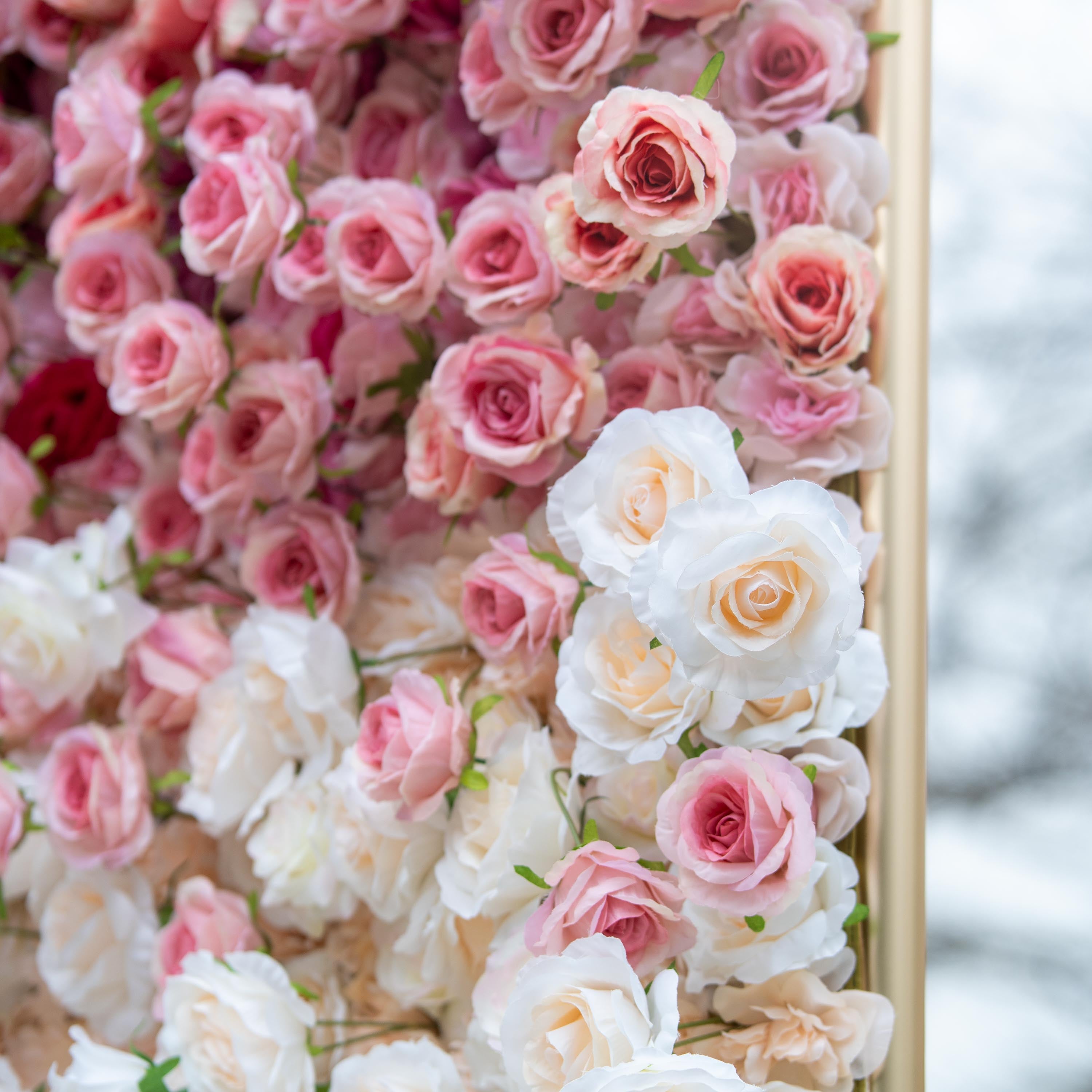 This backdrop features a dense, beautiful arrangement of artificial roses in soft pink and white hues. The roses are meticulously placed, creating a gentle color gradient that exudes a romantic and elegant ambiance, ideal for weddings or special events.