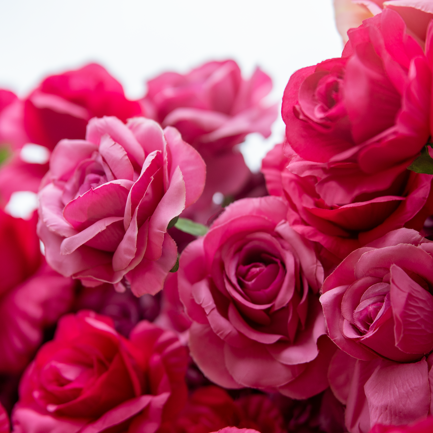 This backdrop showcases a dense cluster of artificial roses in vivid shades of pink. The meticulously crafted petals create a lush, luxurious appearance, exuding a romantic and elegant ambiance, perfect for weddings or special events.
