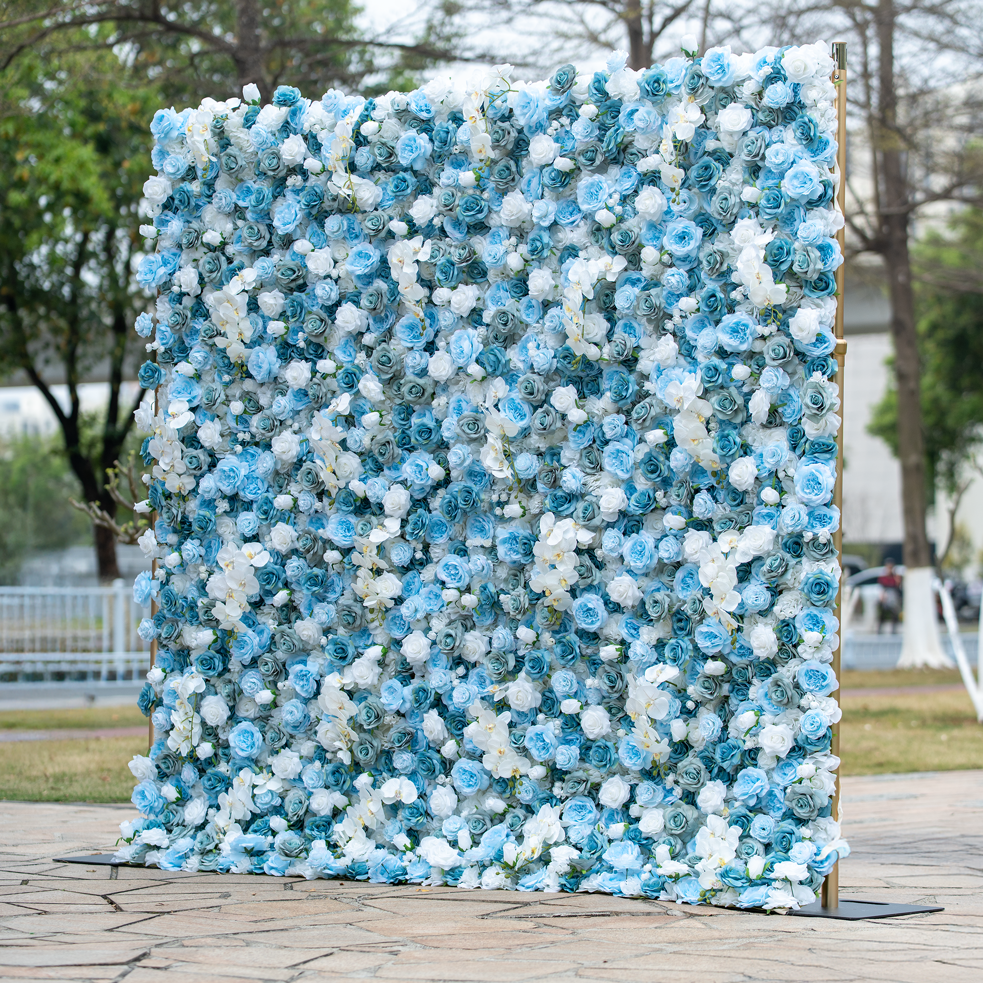 This backdrop is adorned with a dense arrangement of blue and white roses, creating a visually captivating display. The cool - toned flowers exude a serene and elegant charm. Ideal for weddings, galas, or high - end corporate events, it complements themes of sophistication and modern romance. Set outdoors, it adds a touch of natural beauty, making it a stunning focal point for any special occasion.