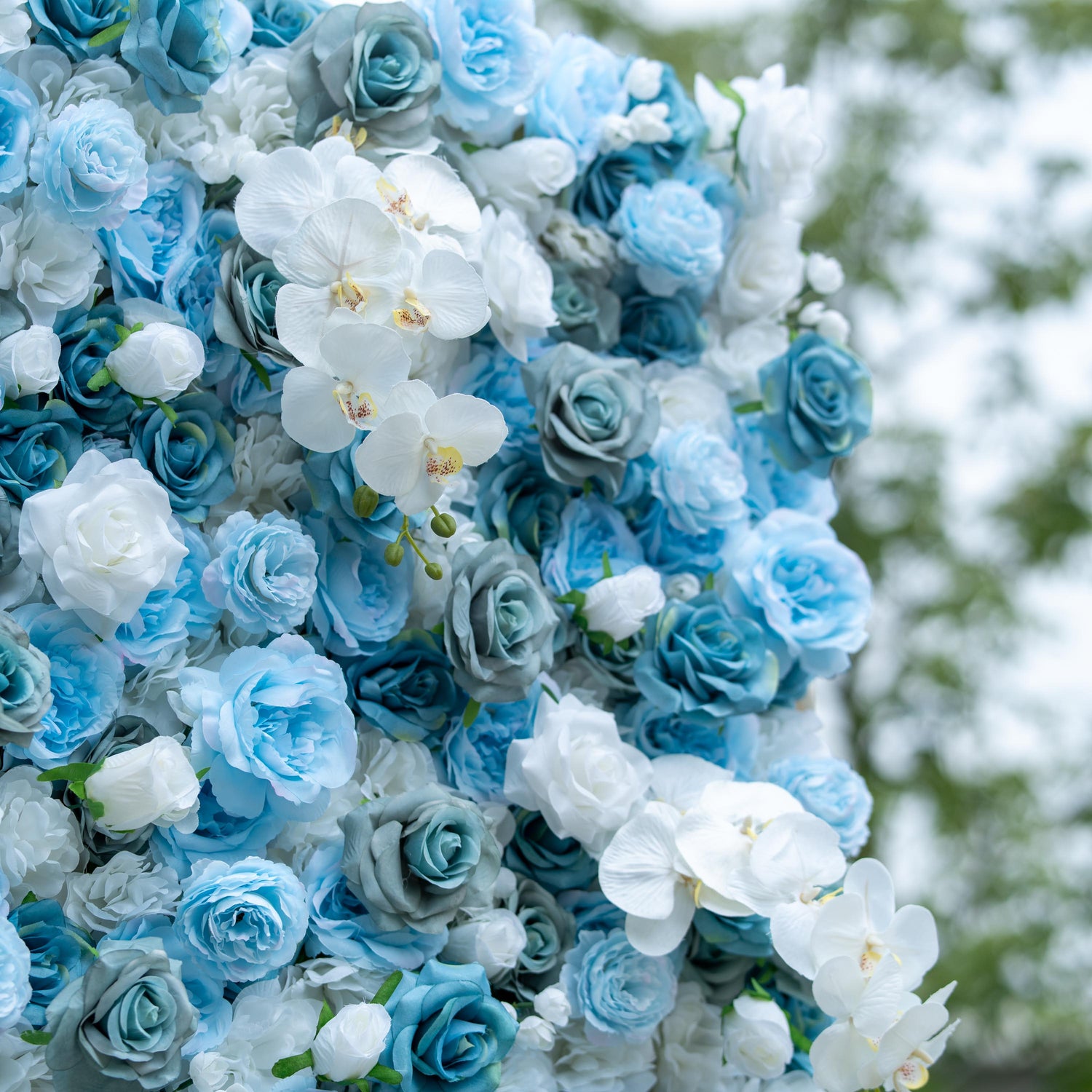 This photo showcases a lush arrangement of blue and white roses intertwined with white orchids. The cool - toned blooms create a serene and elegant display. Ideal for events like anniversary celebrations or charity galas, this backdrop would fit a "Timeless Elegance" theme perfectly. The combination of roses and orchids adds a touch of luxury and refinement, making it a stunning centerpiece for sophisticated gatherings.