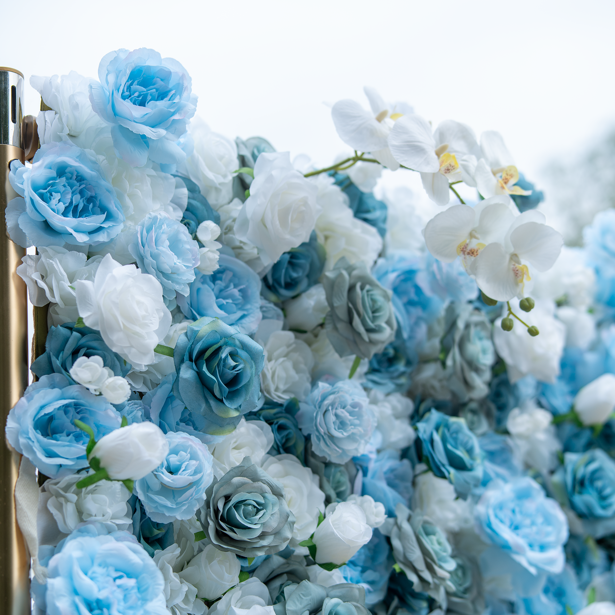 This photo showcases a dense and vibrant floral arrangement featuring a blend of blue and white roses, interspersed with white orchids. The flowers are tightly clustered, creating a lush and textured appearance. The soft hues of blue and white create a calming and elegant atmosphere. This arrangement would be perfect for high - end events such as weddings, galas, or upscale corporate functions, adding a touch of sophistication and beauty to the venue.