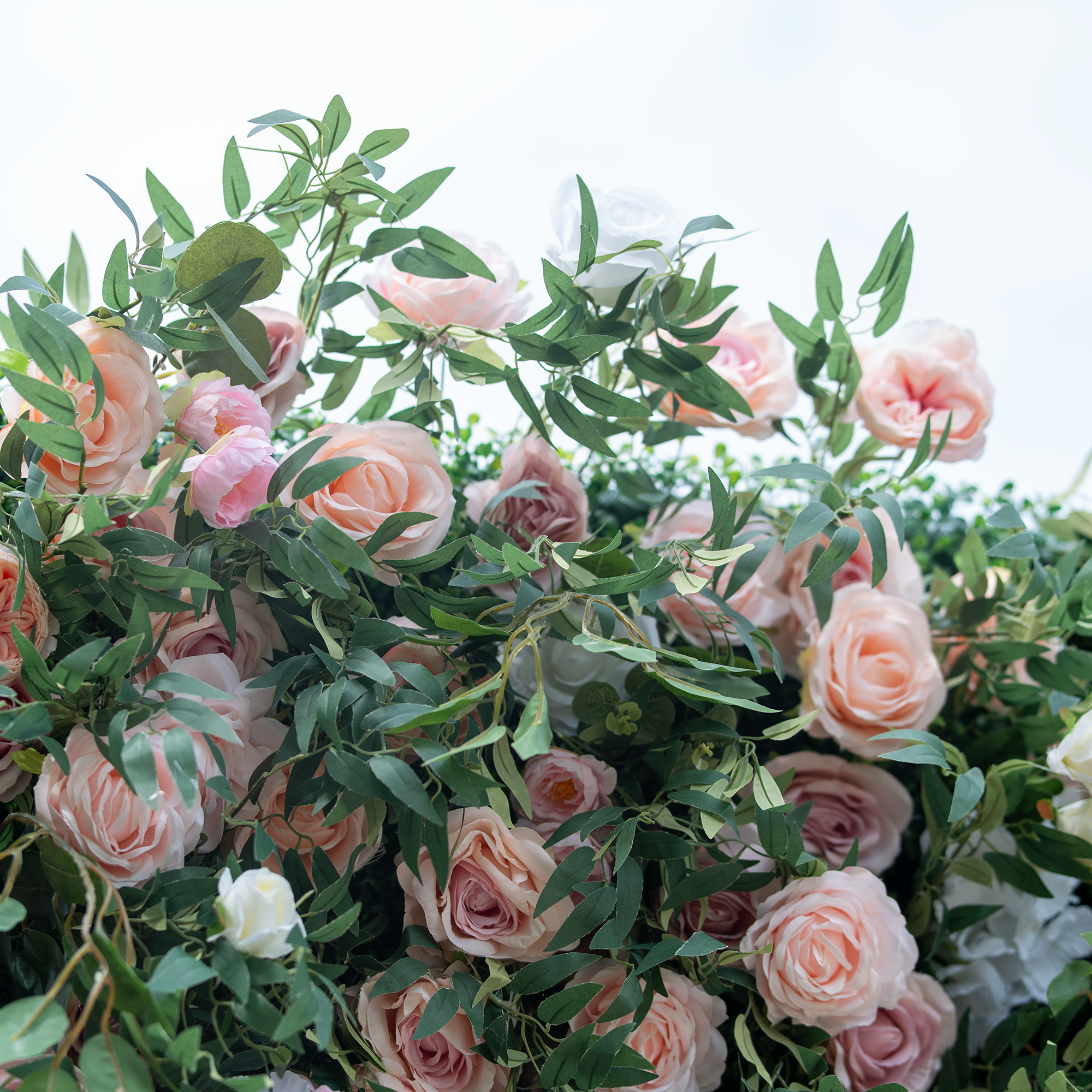 This photo showcases a lush floral arrangement featuring pink and white roses intertwined with green foliage. The soft pastel hues create a romantic and serene atmosphere. Ideal for events like a ladies&
