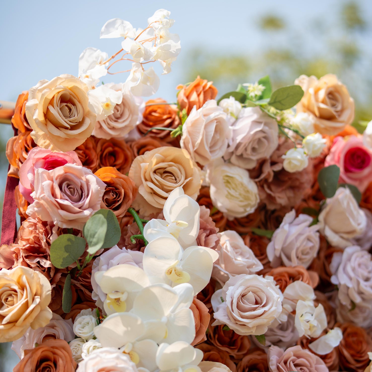 This backdrop showcases a warm, earthy theme with colors like beige, cream, and soft brown. It is densely decorated with roses and white orchids. Ideal for elegant events such as weddings, upscale garden parties, or refined corporate functions.