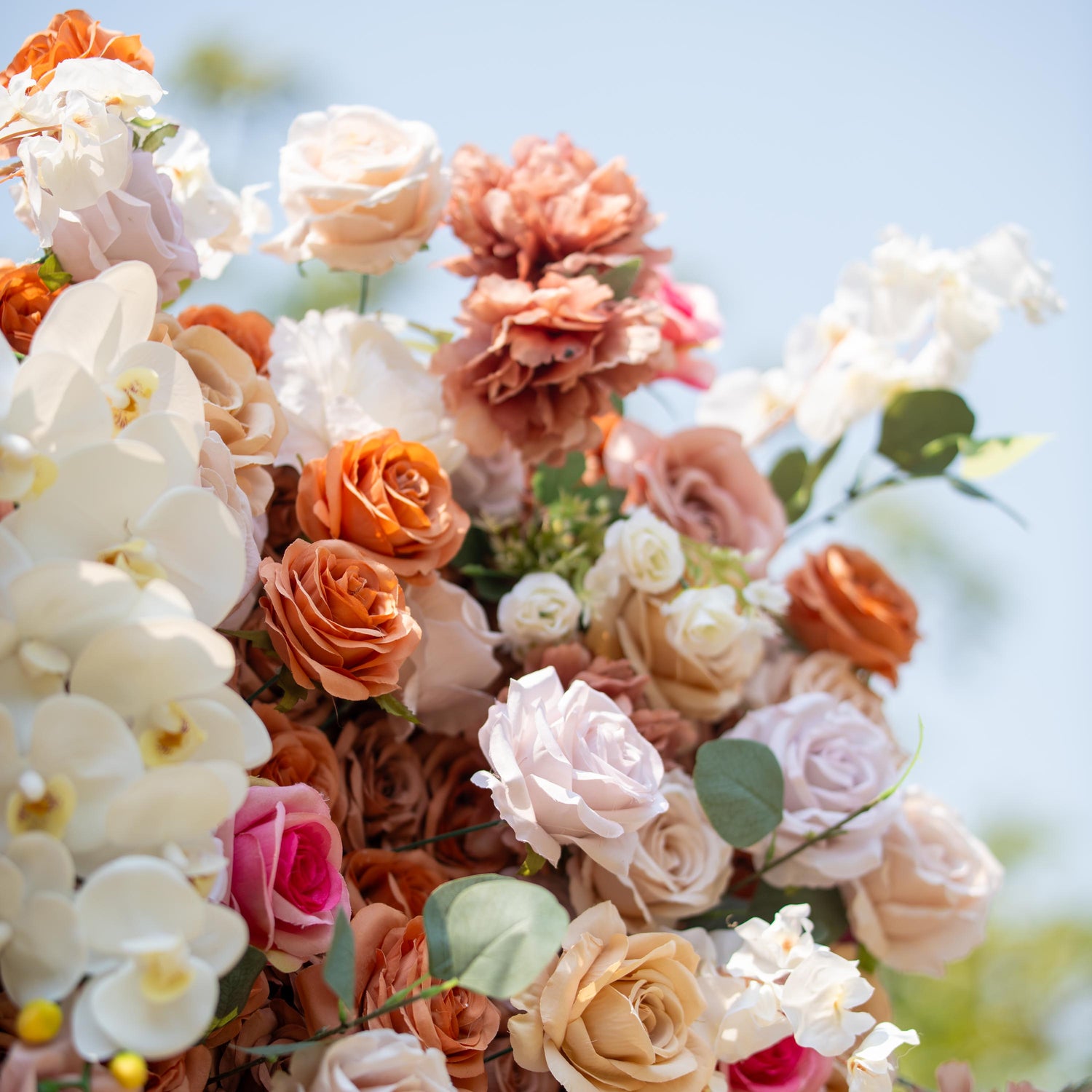 This backdrop presents a warm, earthy theme color palette with shades of beige, cream, and soft brown. It features an array of roses and white orchids. Ideal for sophisticated events like weddings, upscale garden parties, or refined corporate gatherings.