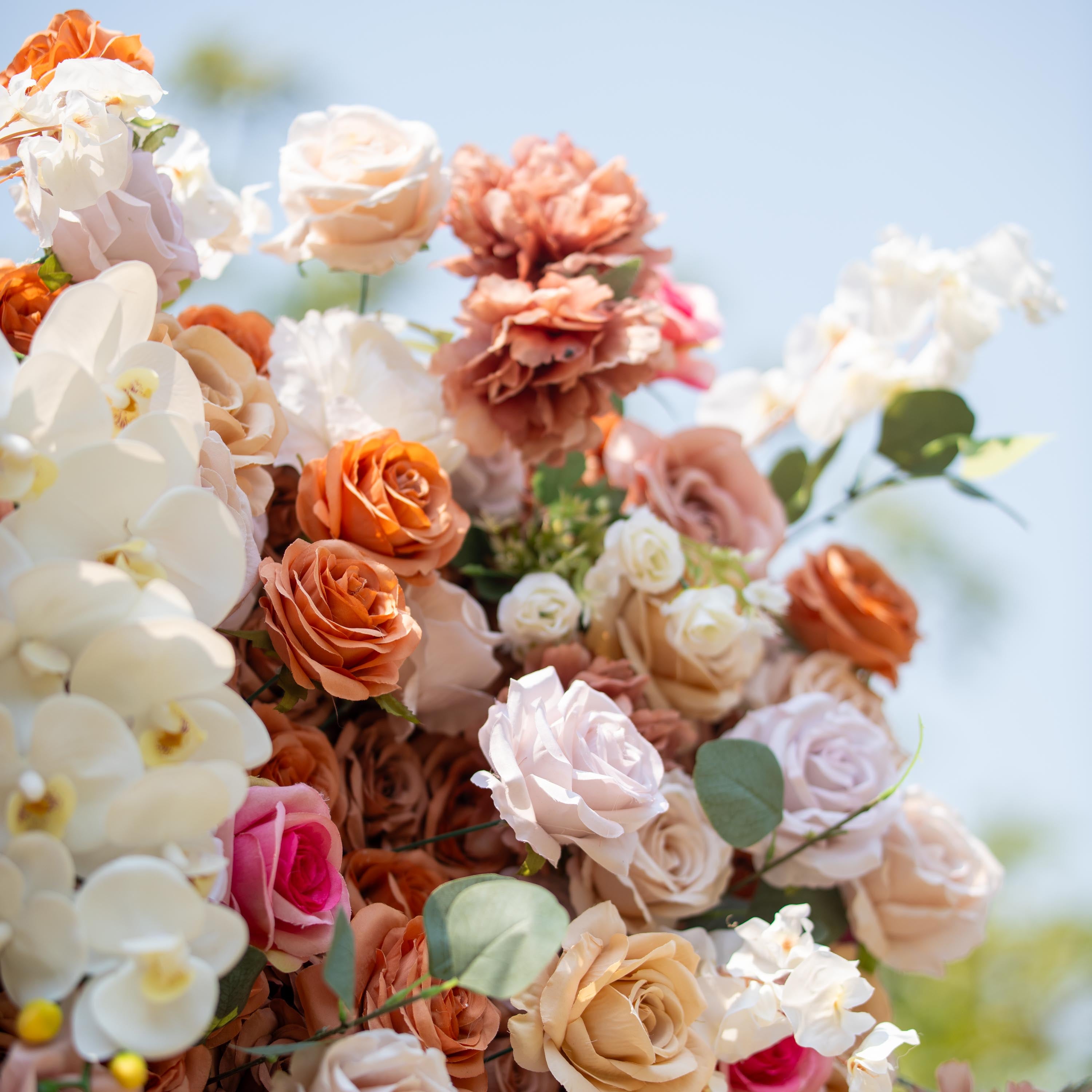 This backdrop presents a warm, earthy theme color palette with shades of beige, cream, and soft brown. It features an array of roses and white orchids. Ideal for sophisticated events like weddings, upscale garden parties, or refined corporate gatherings.