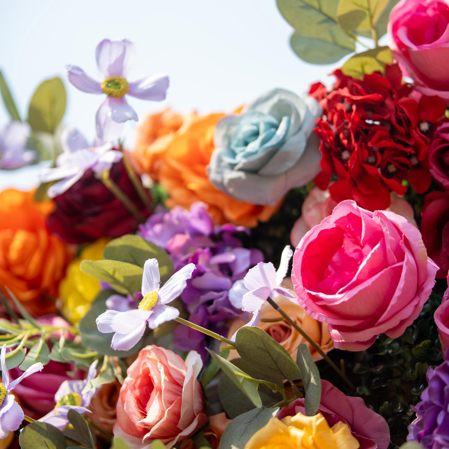 This backdrop flaunts a vivid color theme with shades of pink, orange, yellow, red, purple, and blue. It showcases an array of roses and delicate daisy - like flowers. Perfect for festive outdoor weddings, garden parties, or celebratory events.