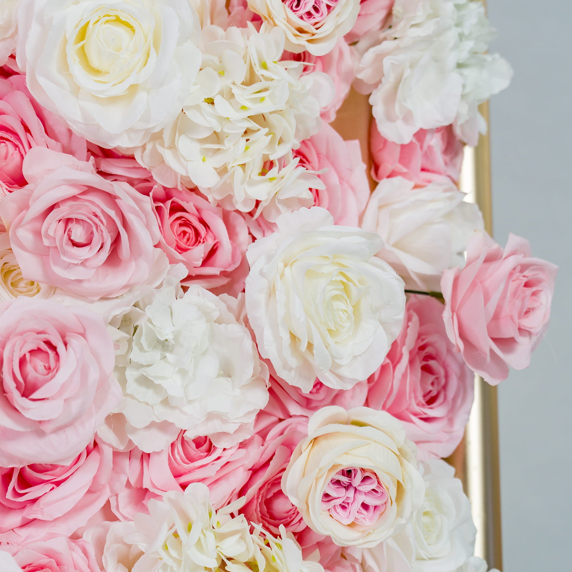This photo features a lush floral backdrop with an abundance of pink and white roses, along with white hydrangeas. The soft pastel color palette creates a romantic and elegant atmosphere. Ideal for weddings or bridal showers, it exudes a dreamy, sophisticated style.