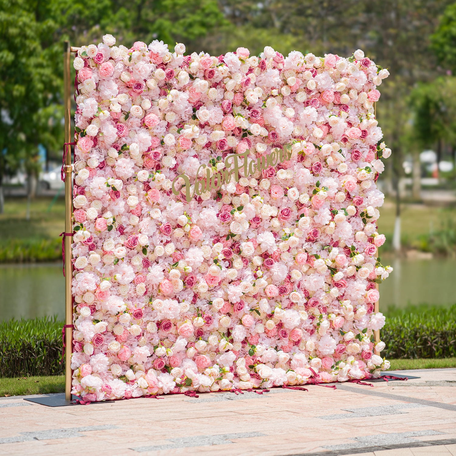 This photo from ValarFlowers showcases a large, sumptuous floral backdrop. Composed of an abundance of pink and white roses and peonies, it exudes a soft, romantic charm. The backdrop is framed by golden supports, enhancing its elegance. Ideal for events like a “Pink Paradise” - themed wedding or a bridal shower, it serves as a stunning decorative centerpiece, creating a dreamy and graceful atmosphere.