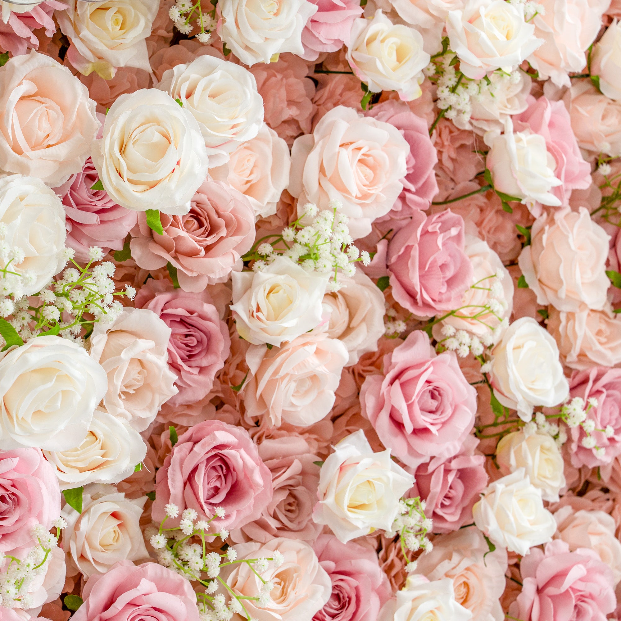 This photo features a lush and dense arrangement of roses in soft pastel shades of pink, peach, and white, interspersed with delicate baby&