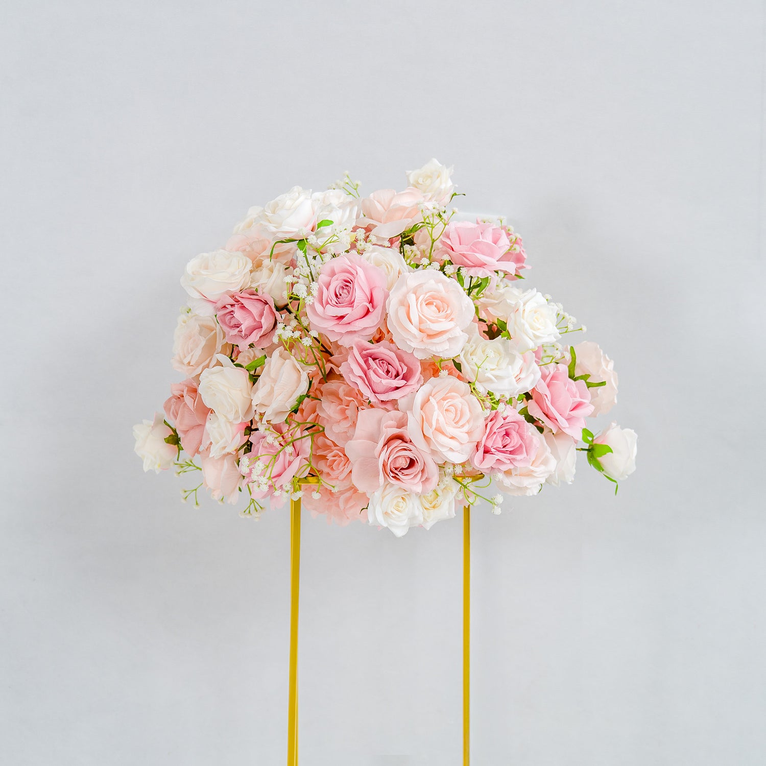 This photo showcases a beautifully arranged floral display. A lush bouquet of pink and white roses, interspersed with delicate baby&