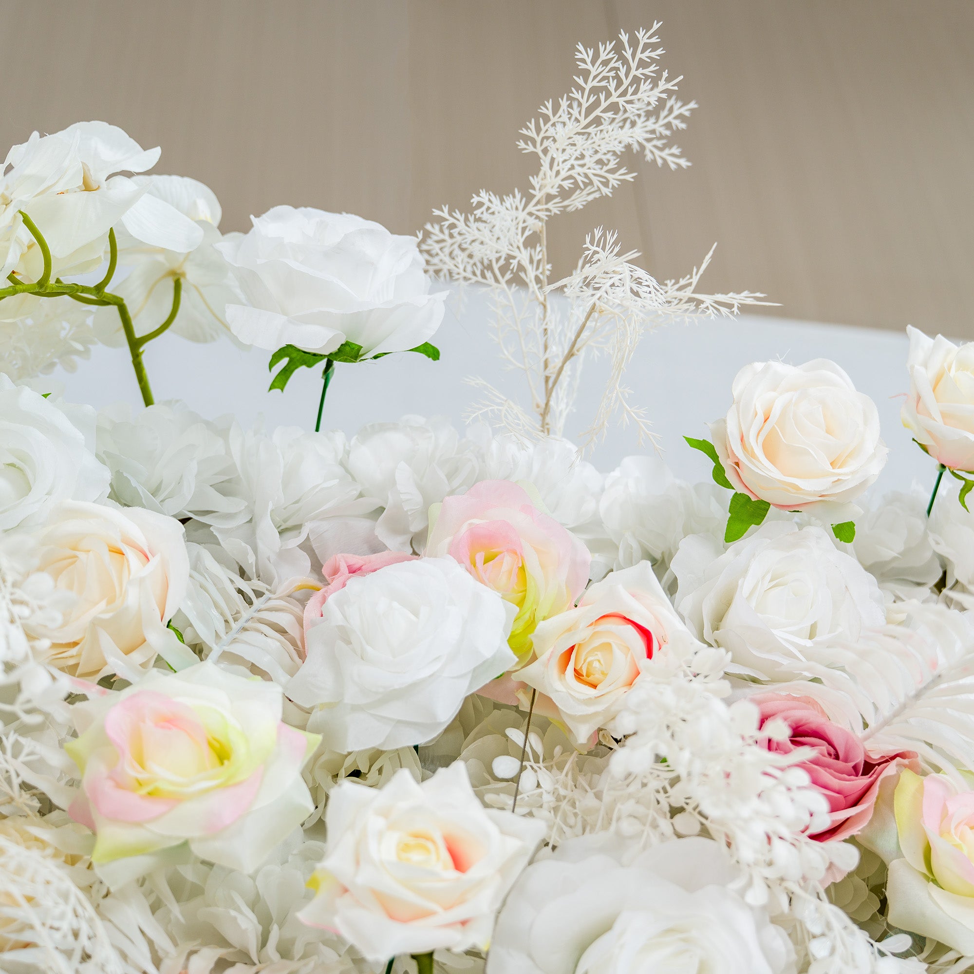 This photo features a lush floral arrangement with white roses, some with soft pink edges, and delicate white foliage. The soft pastel color palette creates an elegant and serene atmosphere. Ideal for weddings, bridal showers, or upscale events, it exudes a refined and dreamy style, perfect for adding a touch of romance.