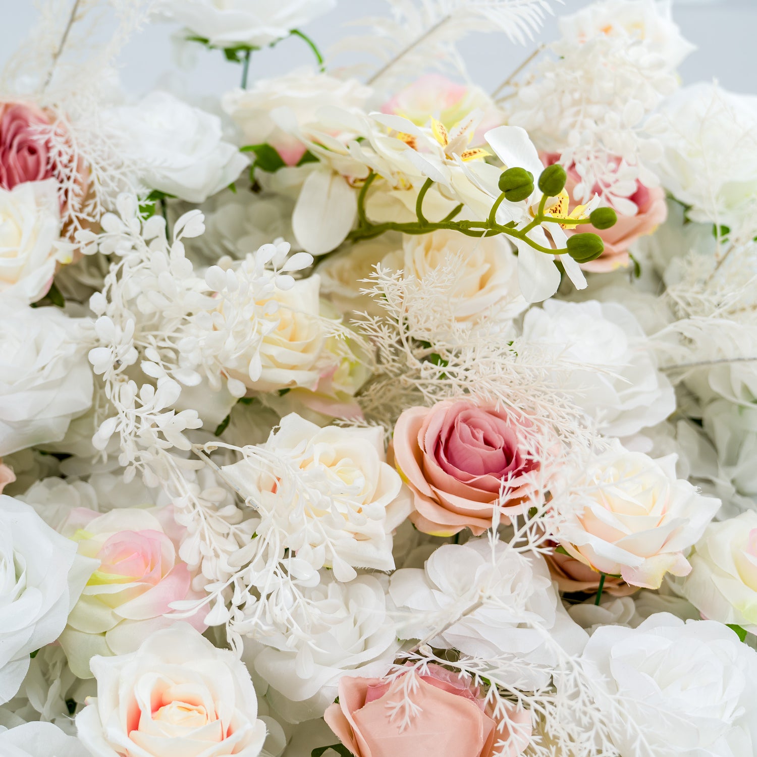 This photo showcases a lush floral arrangement with white roses, some with pinkish - hued edges, and white orchids, complemented by delicate white foliage. The soft pastel color palette creates an elegant and serene atmosphere. Ideal for weddings or upscale events, it exudes a refined, dreamy style.
