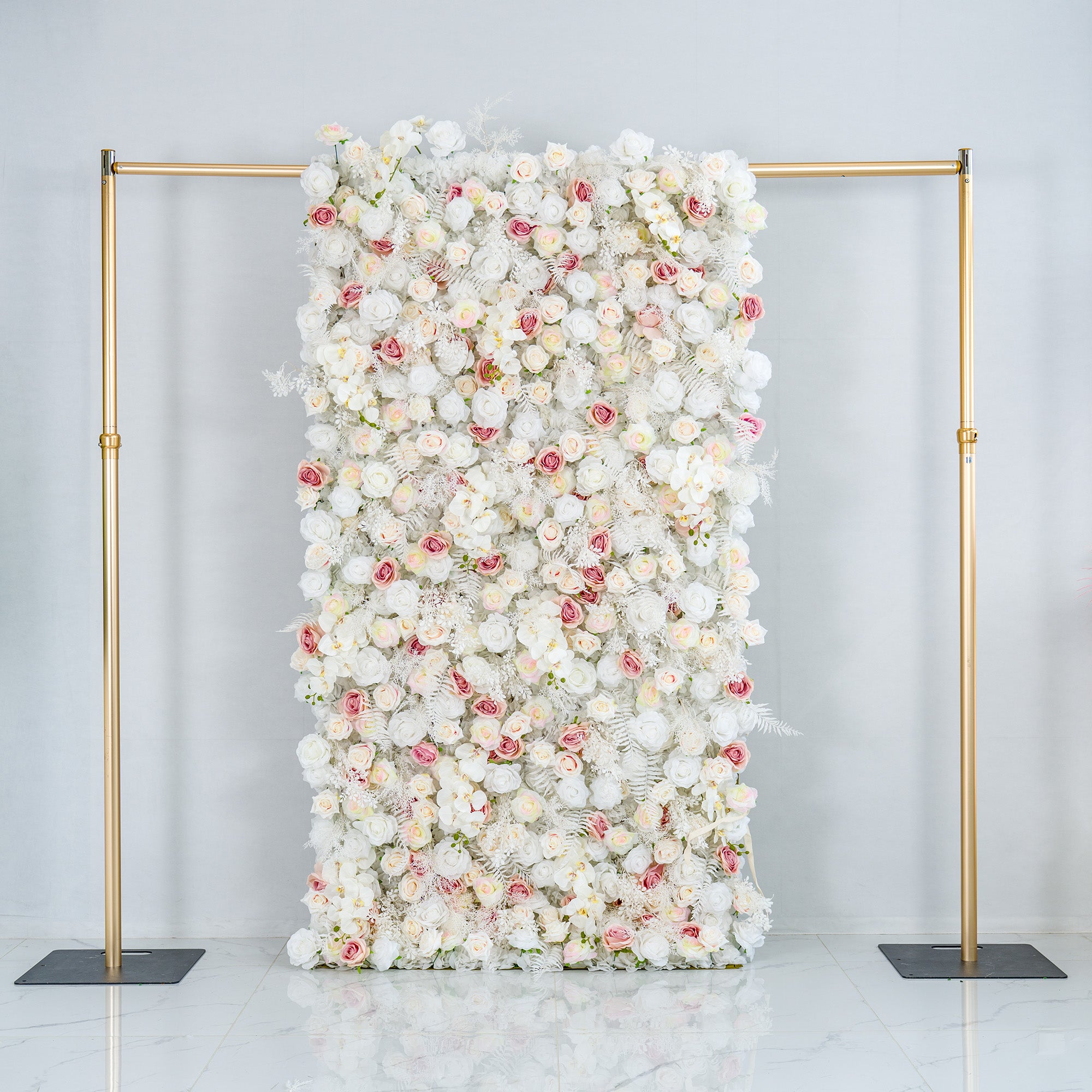 This photo showcases a 4*8ft floral backdrop mounted on a golden stand. It is densely filled with white roses, interspersed with delicate pink roses and white foliage. The soft color palette of white and light pink creates an elegant and serene atmosphere. Ideal for weddings, upscale galas, or sophisticated events, it exudes a refined, dreamy style.
