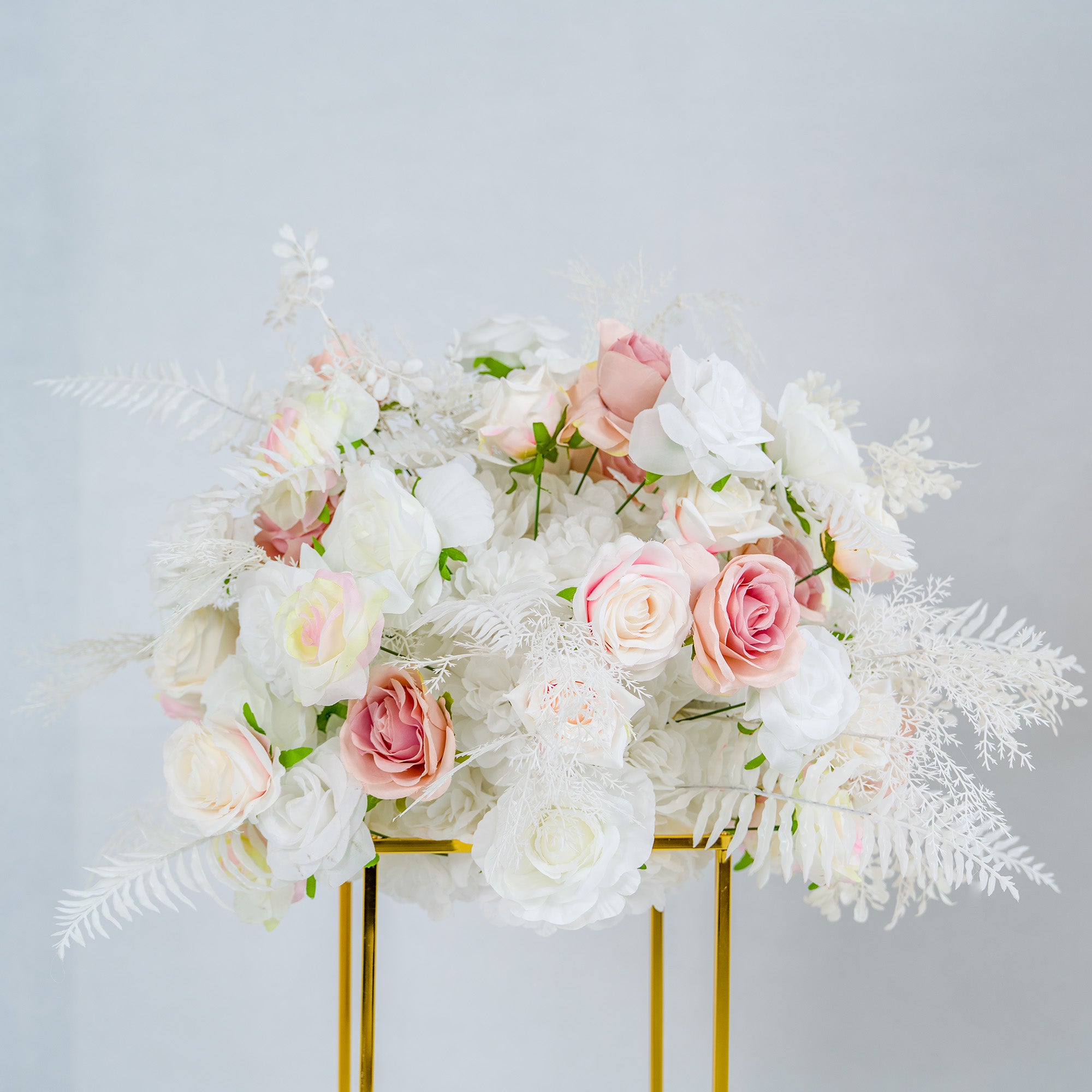 This photo showcases a stunning floral arrangement perfect for weddings or upscale events. It features a lush mix of white and pink roses, complemented by delicate white foliage. The flowers are artfully arranged in a golden - framed stand, exuding elegance. The soft pastel color palette creates a romantic and dreamy ambiance. Ideal for event decor, this floral display is both eye - catching and refined.