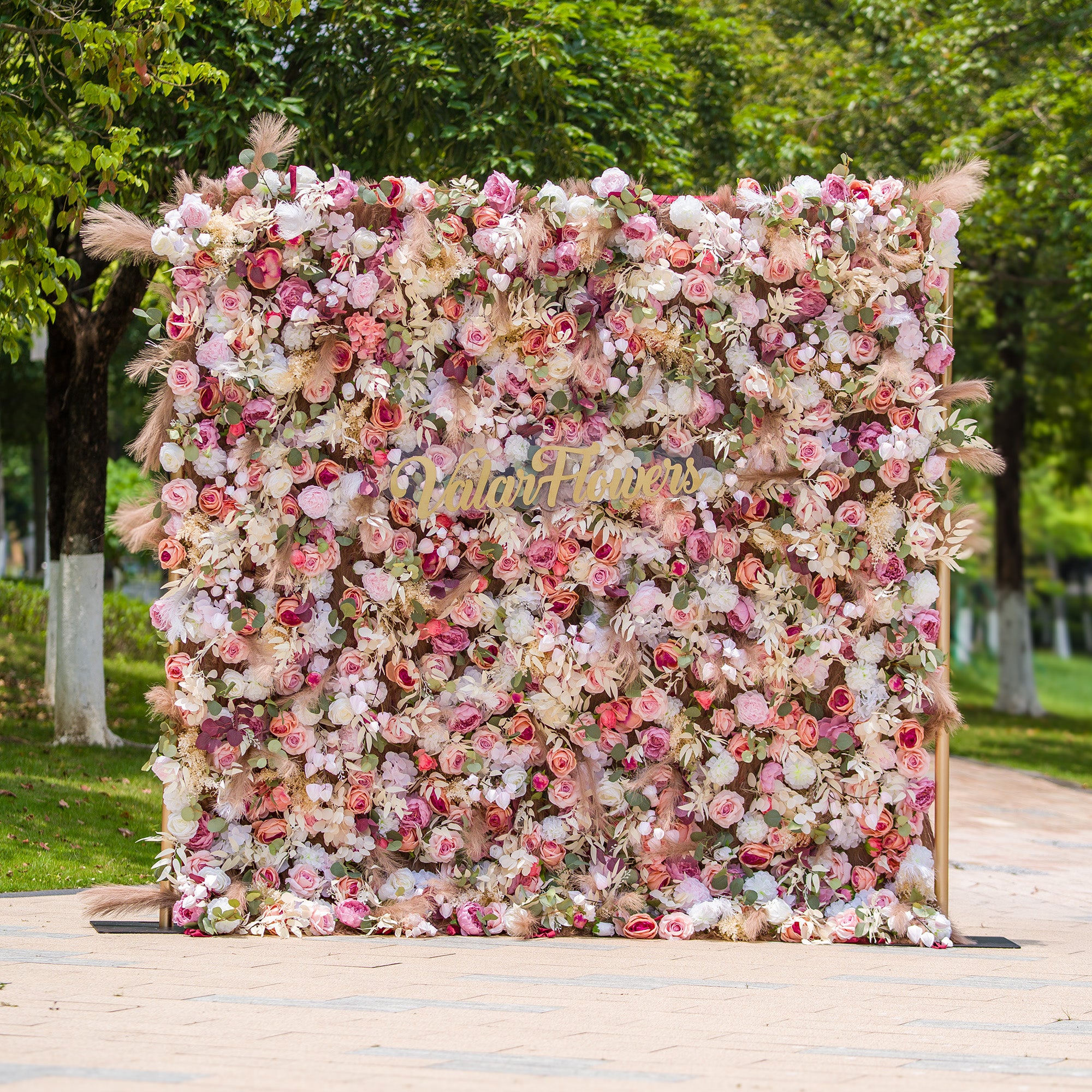 This photo showcases a 2.4x2.4m floral backdrop made by ValarFlowers, densely packed with an array of roses, peonies, and other blooms in soft pinks, whites, and hints of peach. Interspersed with green foliage and pampas grass, it exudes a romantic and elegant vibe. Ideal for events such as a “Romantic Blush” wedding or a spring - themed garden party, it creates a dreamy atmosphere.