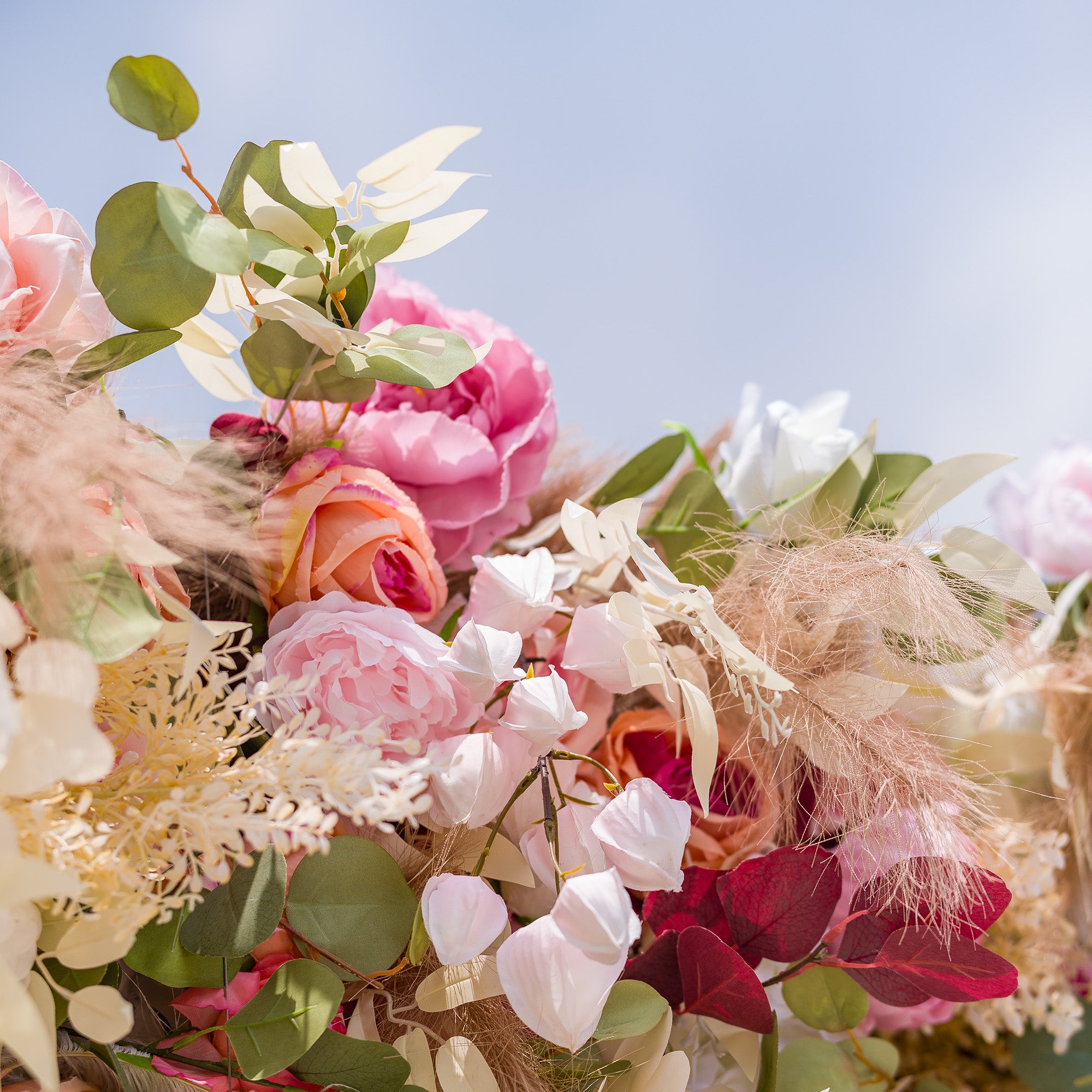This photo captures a vibrant and lush arrangement of artificial flowers. It features a variety of blooms in soft pastel shades like pink, peach, and white, interspersed with green eucalyptus leaves and delicate pampas grass. The combination creates a romantic and elegant display, perfect for events such as weddings, engagement parties, or high - end garden soirees, adding a dreamy atmosphere to the occasion.