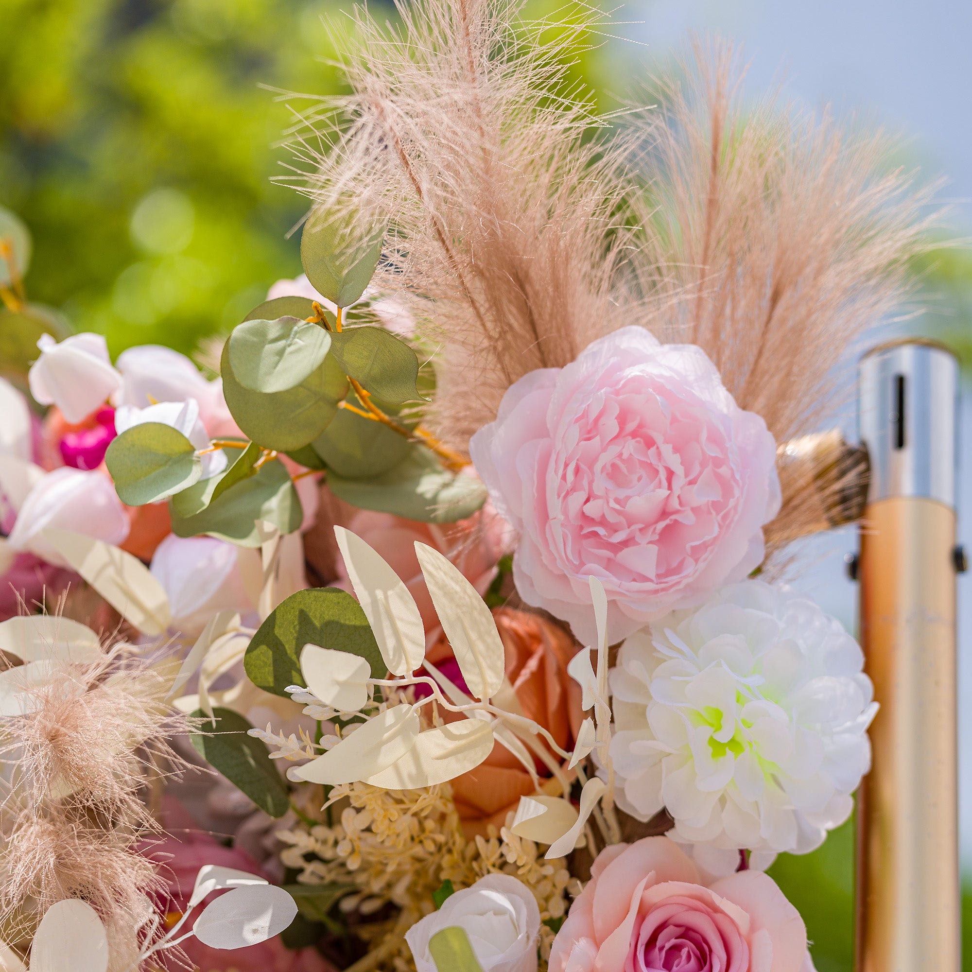 This photo showcases a lush floral arrangement featuring an array of roses, peonies, and other delicate blooms in soft pink, peach, and white hues. Interspersed with eucalyptus leaves and fluffy pampas grass, it exudes romance. Ideal for events like a “Sweet Blossom” wedding or a spring - themed bridal shower, it creates a dreamy, elegant atmosphere.