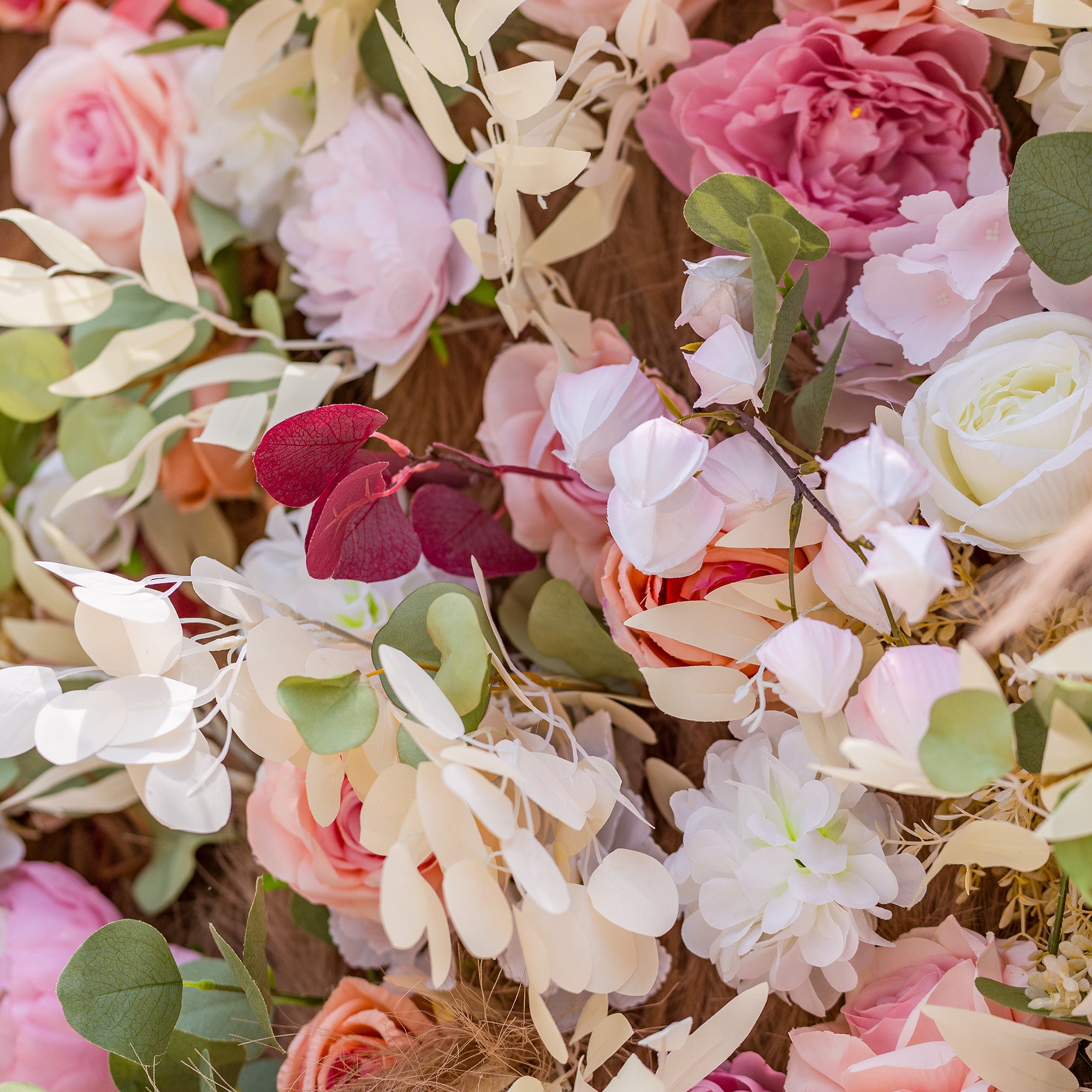 This photo displays a lush, vibrant floral arrangement featuring an assortment of roses and peonies in soft pink, peach, and white tones. Eucalyptus leaves in green and deep red add contrast, along with delicate white blooms and pampas grass. Ideal for a “Blossoming Love” wedding or a spring - themed garden party, it exudes a romantic, dreamy ambiance.