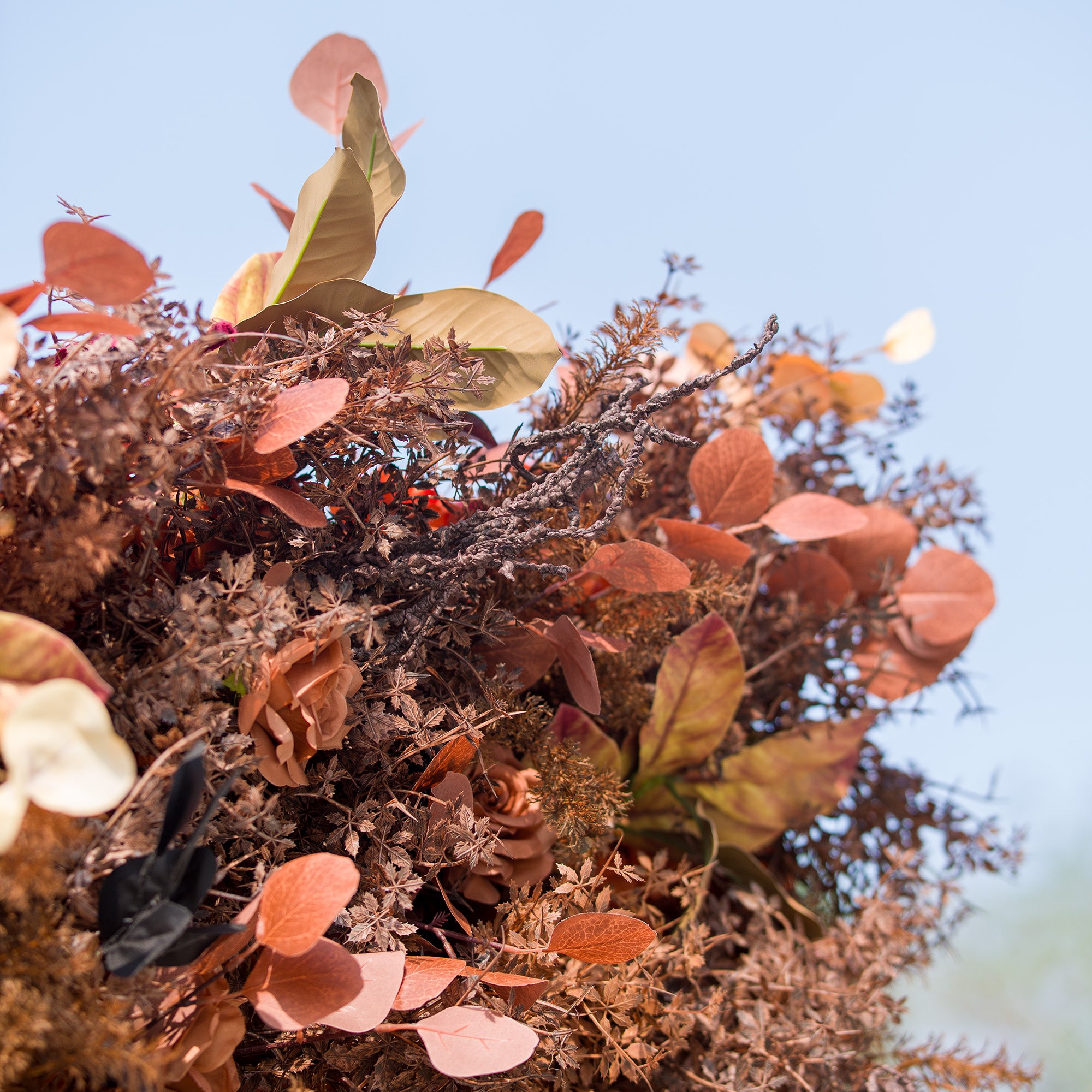 This photo showcases a rich arrangement of autumn - inspired flowers and foliage. The display features roses in warm brown tones, complemented by various dried - look leaves in shades of rust, copper, and orange. Ideal for events like an “Autumn Equinox” celebration or a harvest - themed wedding, it exudes rustic, seasonal charm.