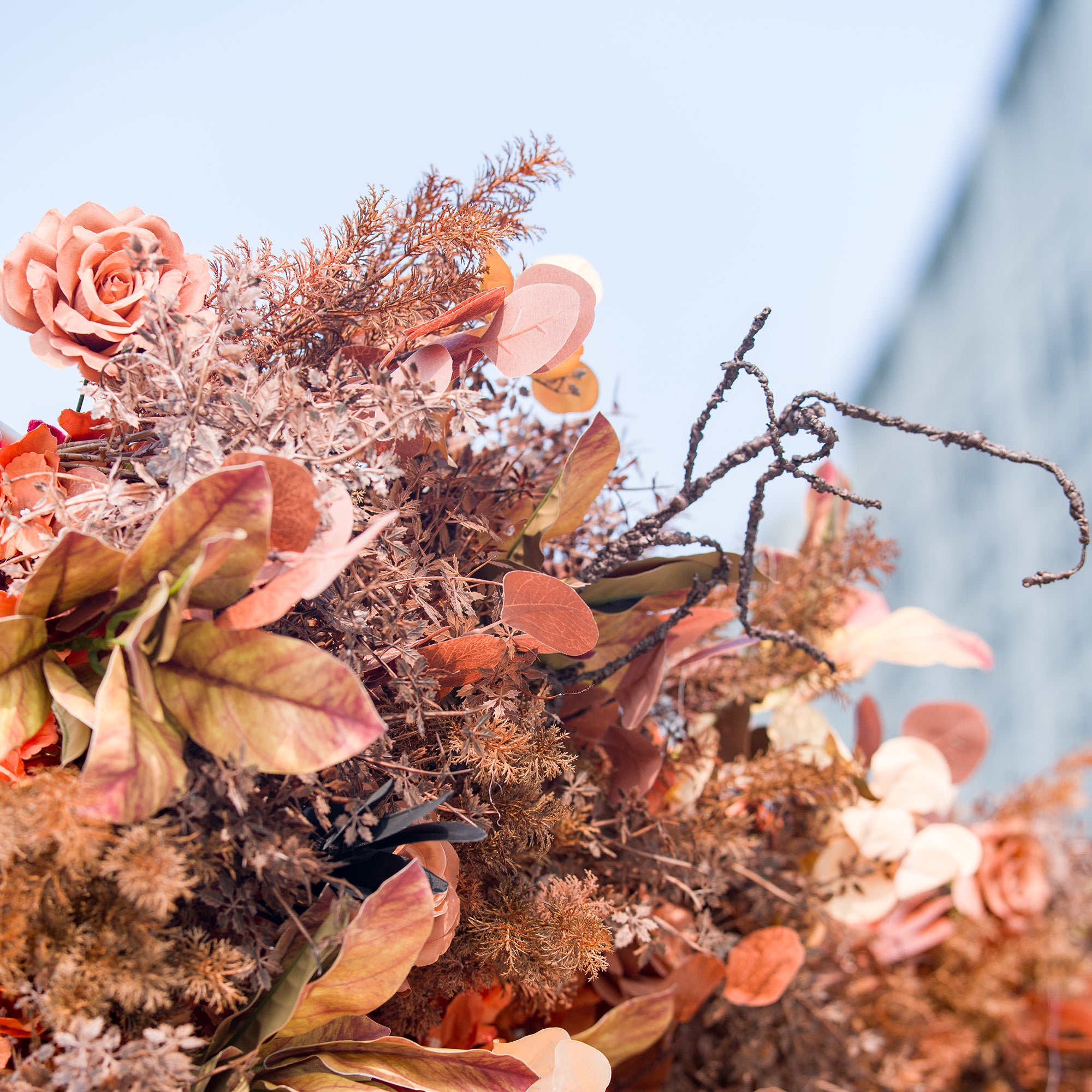 This photo showcases a rich arrangement of autumn - themed flowers and foliage. Rust - colored roses and a variety of leaves in shades of orange, brown, and copper create a textured, warm display. Ideal for events like an “Autumn Glow” wedding, a fall - inspired party, or a Halloween party, it exudes cozy, seasonal charm.