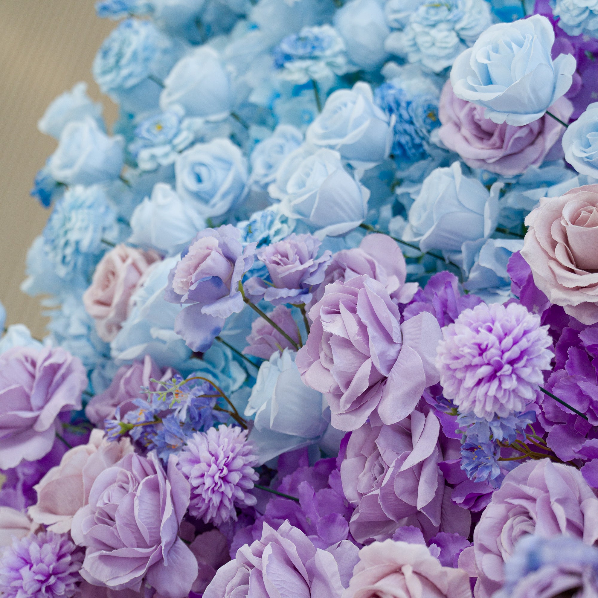 This photo showcases a lush floral arrangement with roses, chrysanthemums, and small blue blooms. The color theme blends soft lavender, pale pink, and light blue, creating a dreamy, romantic vibe. Perfect for weddings, bridal showers, or upscale events, the pastel hues and varied flower types form an eye - catching, elegant backdrop. The gradient of cool tones adds depth, making it ideal for memorable photo moments at sophisticated celebrations.
