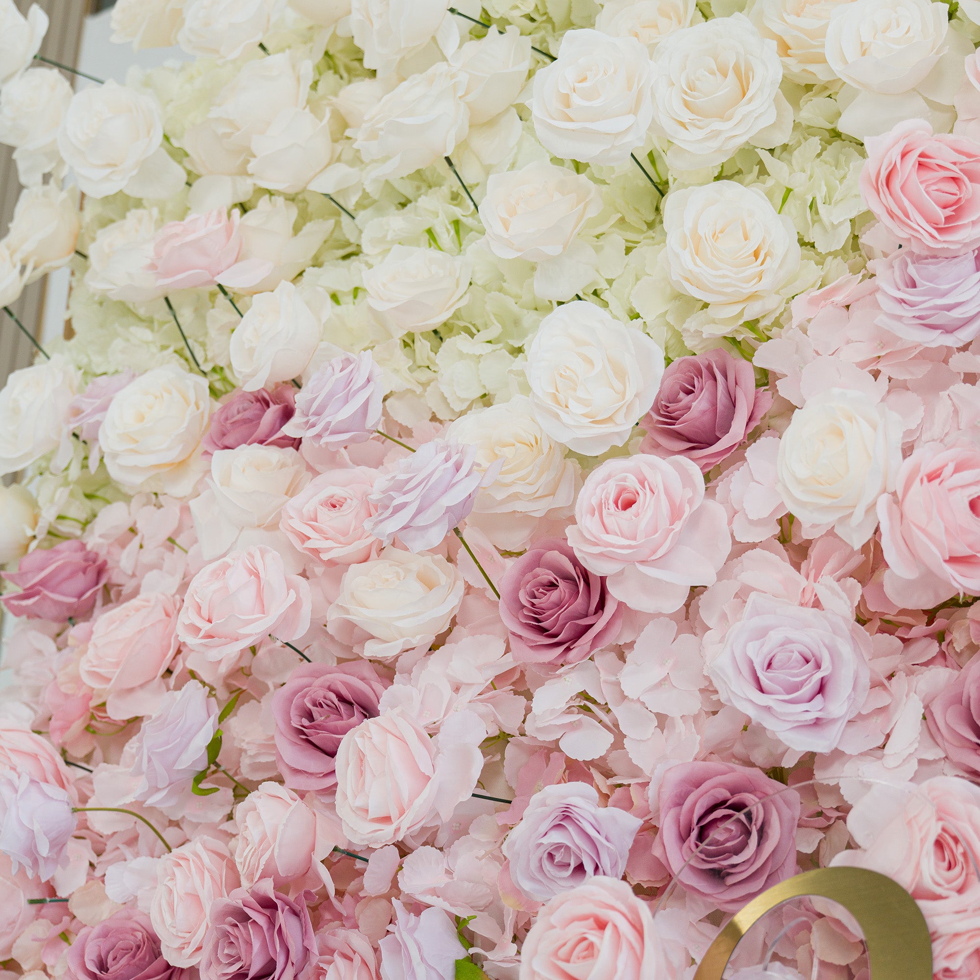 A lush floral wall showcases light - yellow roses at the top, transitioning to soft pink and lavender blooms. The gradient color theme, from lime to pastel pink/purple, creates a romantic and elegant vibe, making it perfect for weddings or upscale events. Dense, layered flowers offer a dreamy and polished backdrop, blending natural beauty with sophistication.