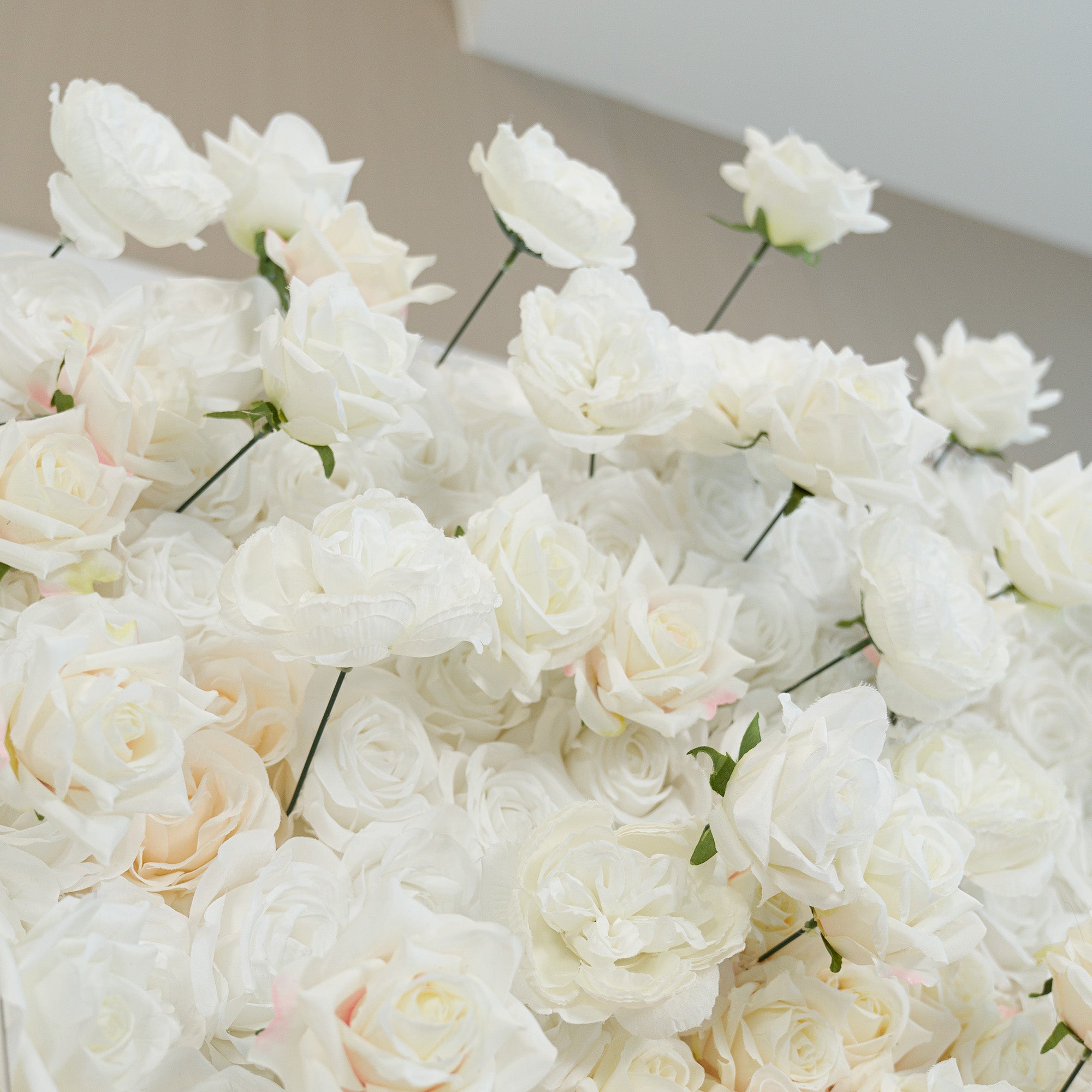 A lush arrangement of white roses, their petals soft and pristine. These artificial flowers create a pure, elegant color theme—ideal for weddings, bridal showers, or formal events. The monochromatic white exudes timeless romance and sophistication, perfect for backdrops, decor, or centerpieces needing a classic, refined touch.