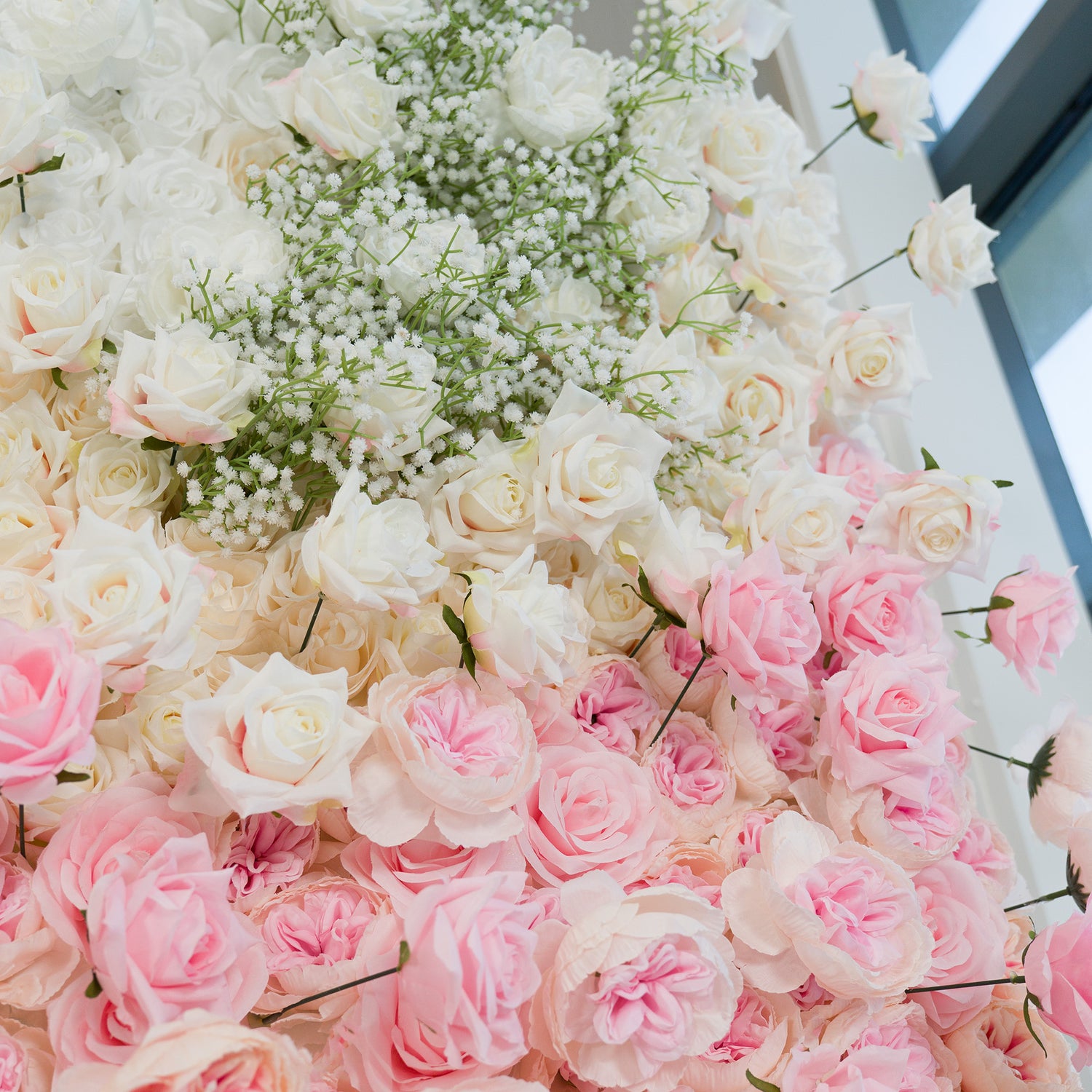 This elegant floral arrangement features white roses, soft pink roses, and baby’s breath. The color theme—white, blush pink, and delicate green—creates a romantic, dreamy vibe. Perfect for weddings, bridal events, or intimate celebrations, it blends classic blooms for a timeless, sophisticated look, ideal as a backdrop or decor centerpiece.