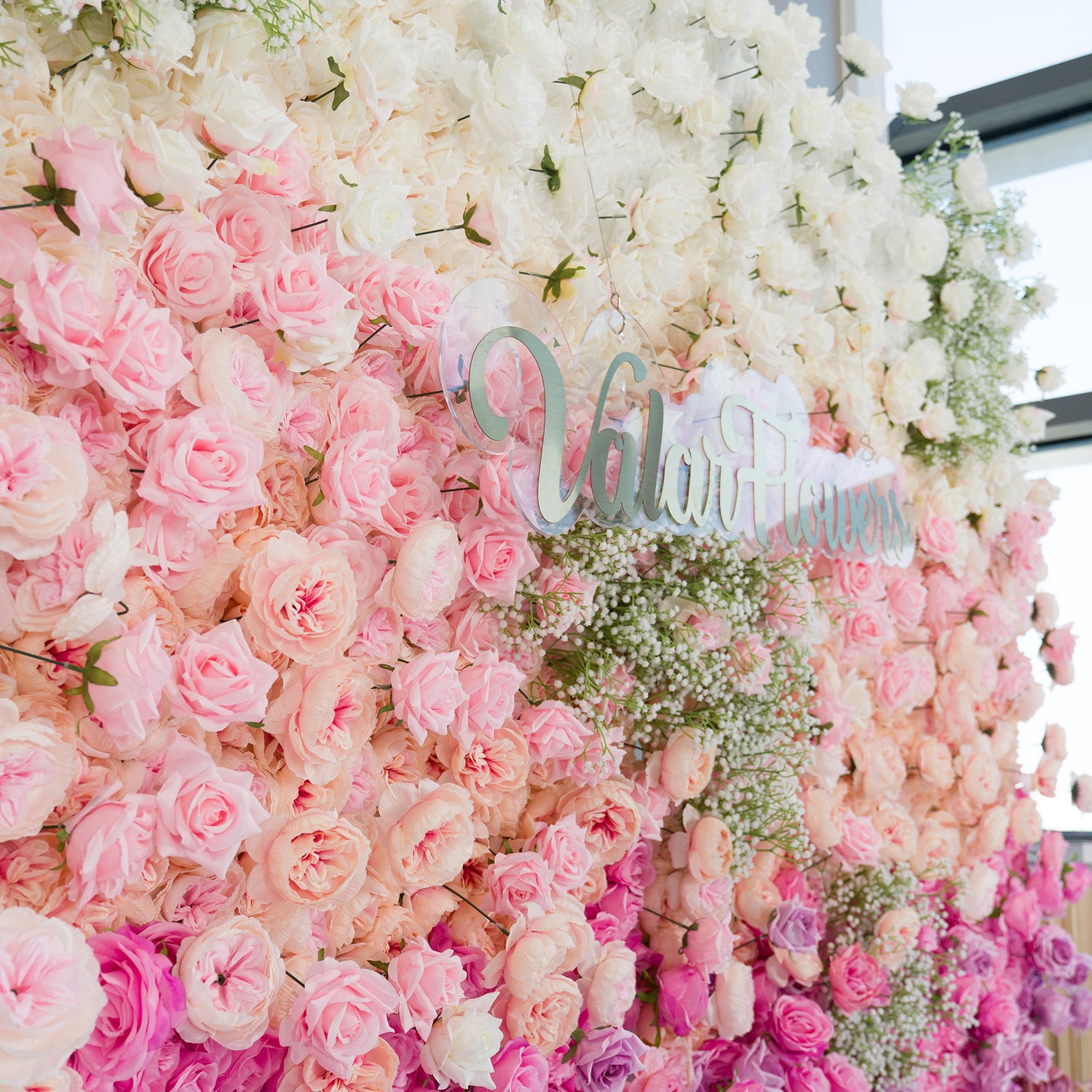 This stunning floral wall by ValarFlowers features white roses, soft pink roses, and baby’s breath. The color theme—white, blush pink, and delicate green—creates a romantic, dreamy vibe. Perfect for weddings, bridal events, or intimate celebrations, it blends classic blooms for a timeless, sophisticated look, ideal as a backdrop or decor centerpiece.