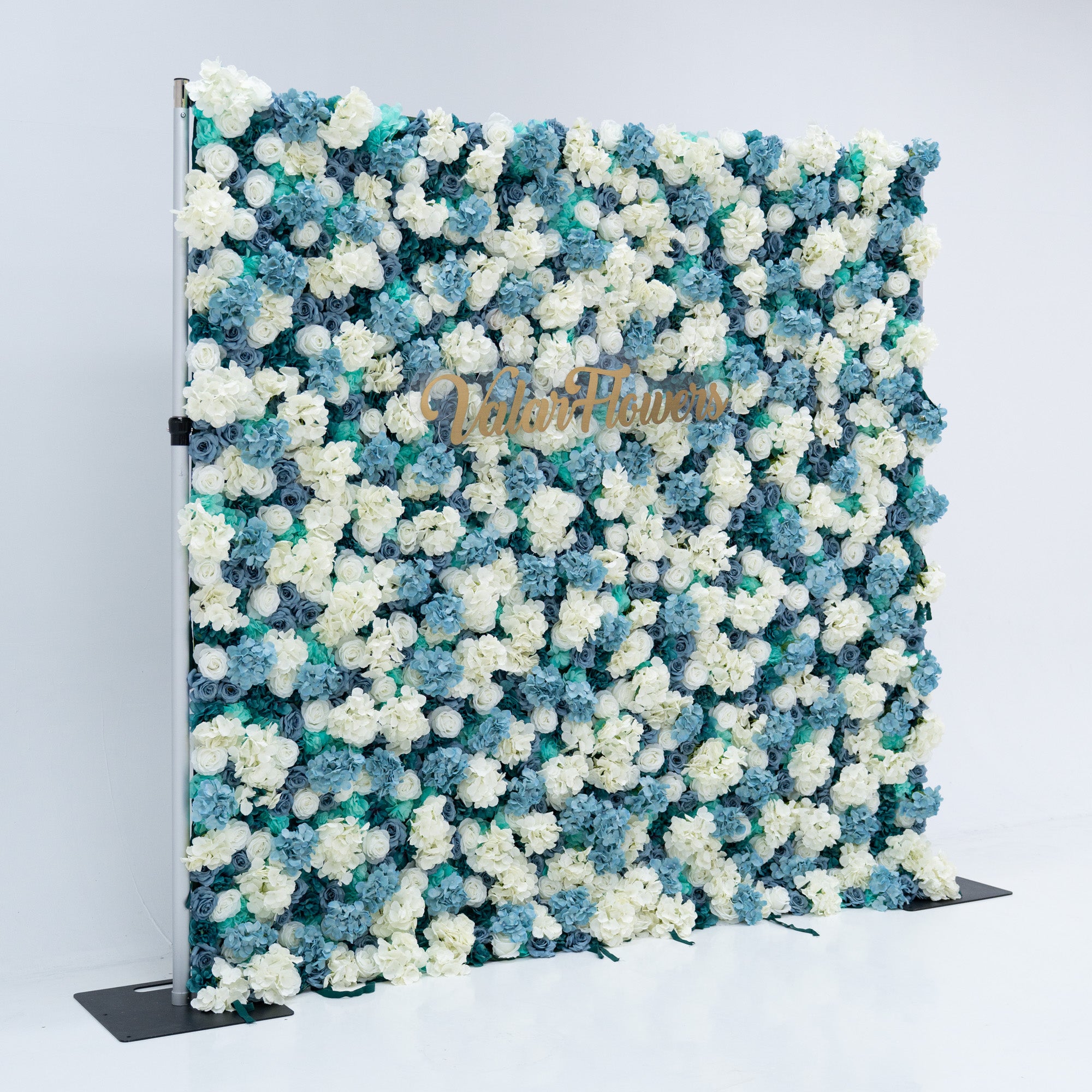 The backdrop is set against a plain white background, creating a clean and elegant look. The gold lettering of "Valar Flowers" adds a touch of sophistication, making it an ideal decorative piece for weddings, photo shoots, or other special events. The roses are meticulously arranged to create a visually appealing pattern, enhancing the overall aesthetic of the backdrop.