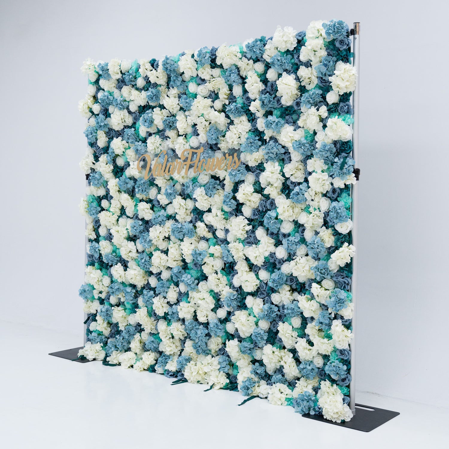 The backdrop is set against a plain white background, creating a clean and elegant look. The gold lettering of "Valar Flowers" adds a touch of sophistication, making it an ideal decorative piece for weddings, photo shoots, or other special events. The roses are meticulously arranged to create a visually appealing pattern, enhancing the overall aesthetic of the backdrop.