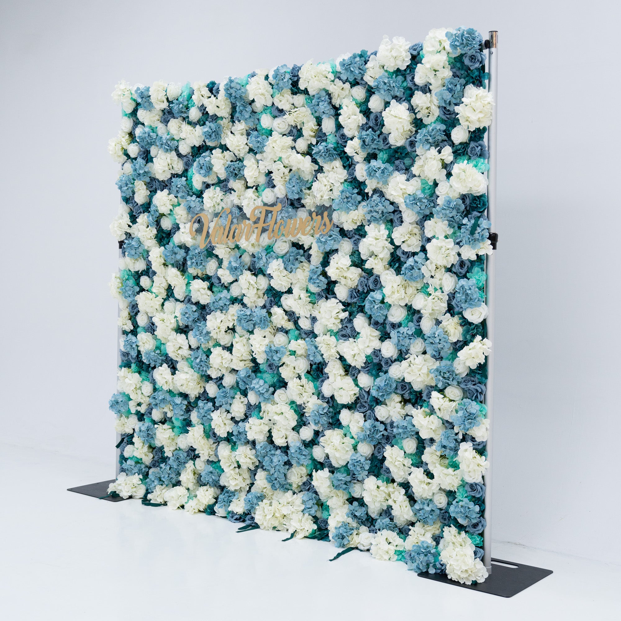 The backdrop is set against a plain white background, creating a clean and elegant look. The gold lettering of "Valar Flowers" adds a touch of sophistication, making it an ideal decorative piece for weddings, photo shoots, or other special events. The roses are meticulously arranged to create a visually appealing pattern, enhancing the overall aesthetic of the backdrop.