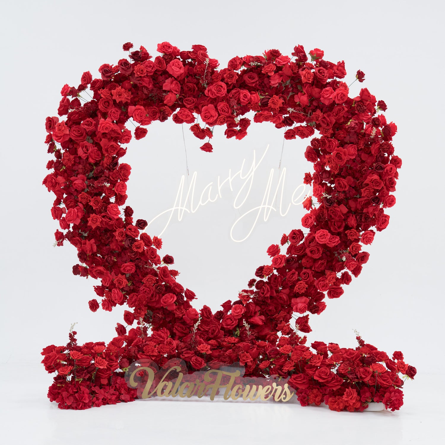 A heart - shaped floral display crafted from dense red roses. At its center, a “Marry Me” sign glows, and the base features a “Valar Flowers” plaque. The vibrant, romantic arrangement is perfect for proposals, blending beauty and sentiment to create a memorable moment.