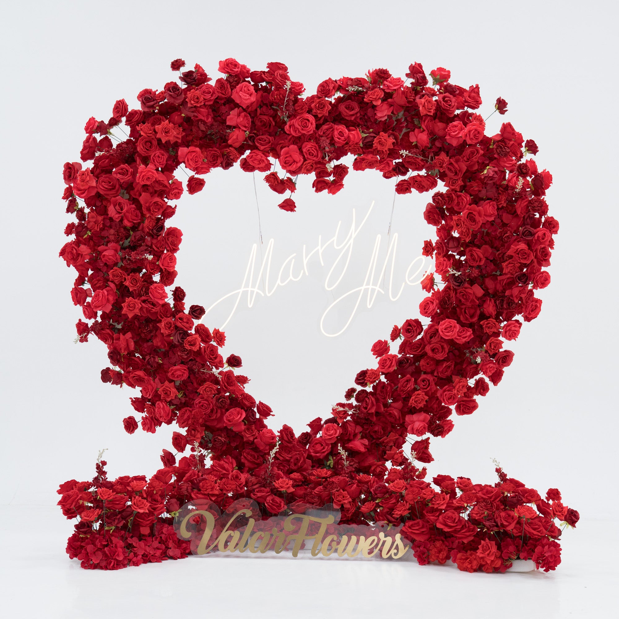 A heart - shaped floral display crafted from dense red roses. At its center, a “Marry Me” sign glows, and the base features a “Valar Flowers” plaque. The vibrant, romantic arrangement is perfect for proposals, blending beauty and sentiment to create a memorable moment.