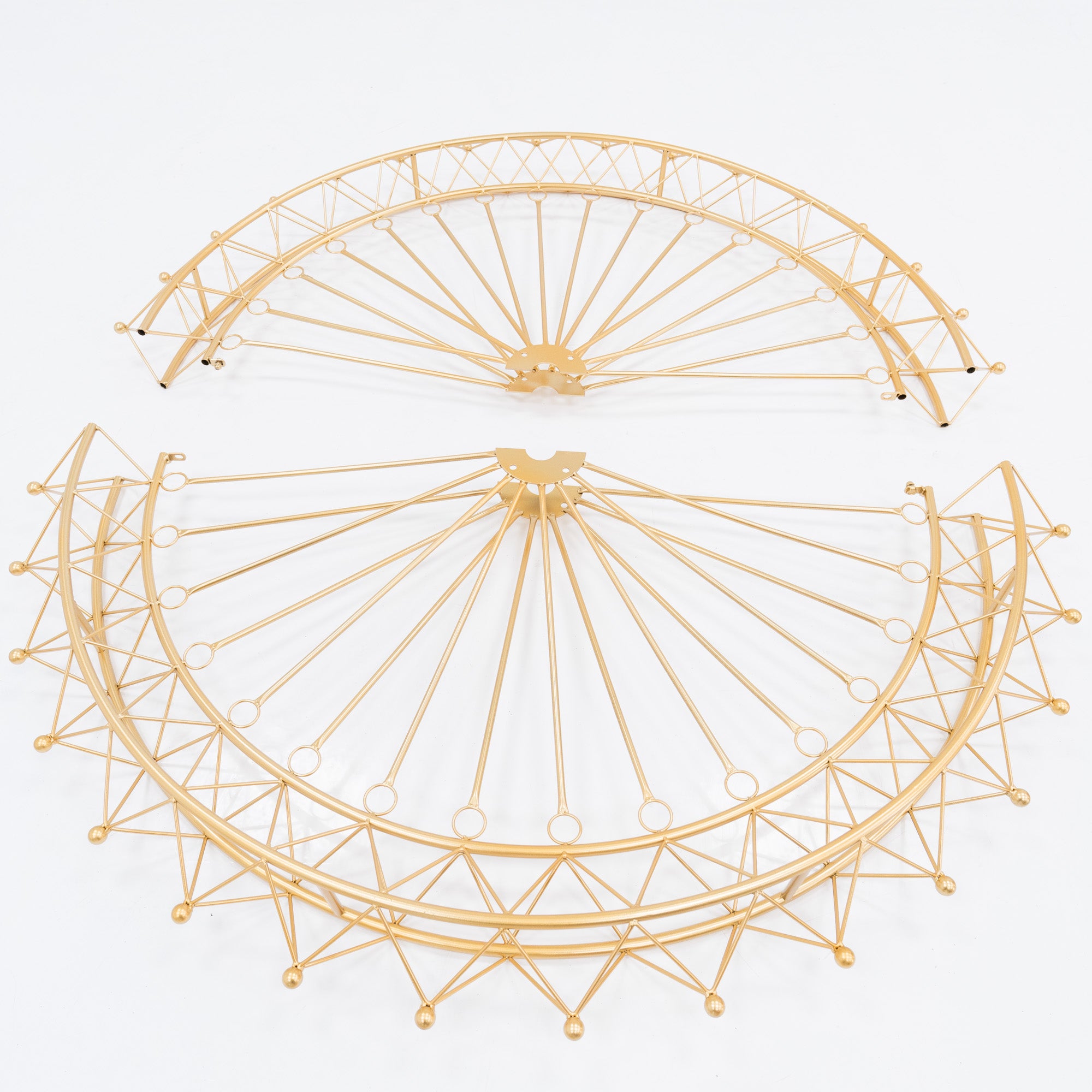 Two golden, semi - circular metal frames, parts of a Ferris wheel decoration. Intricate spoke and lattice designs create a delicate, decorative structure. The shimmering gold finish adds elegance, ideal for assembling themed event decor.