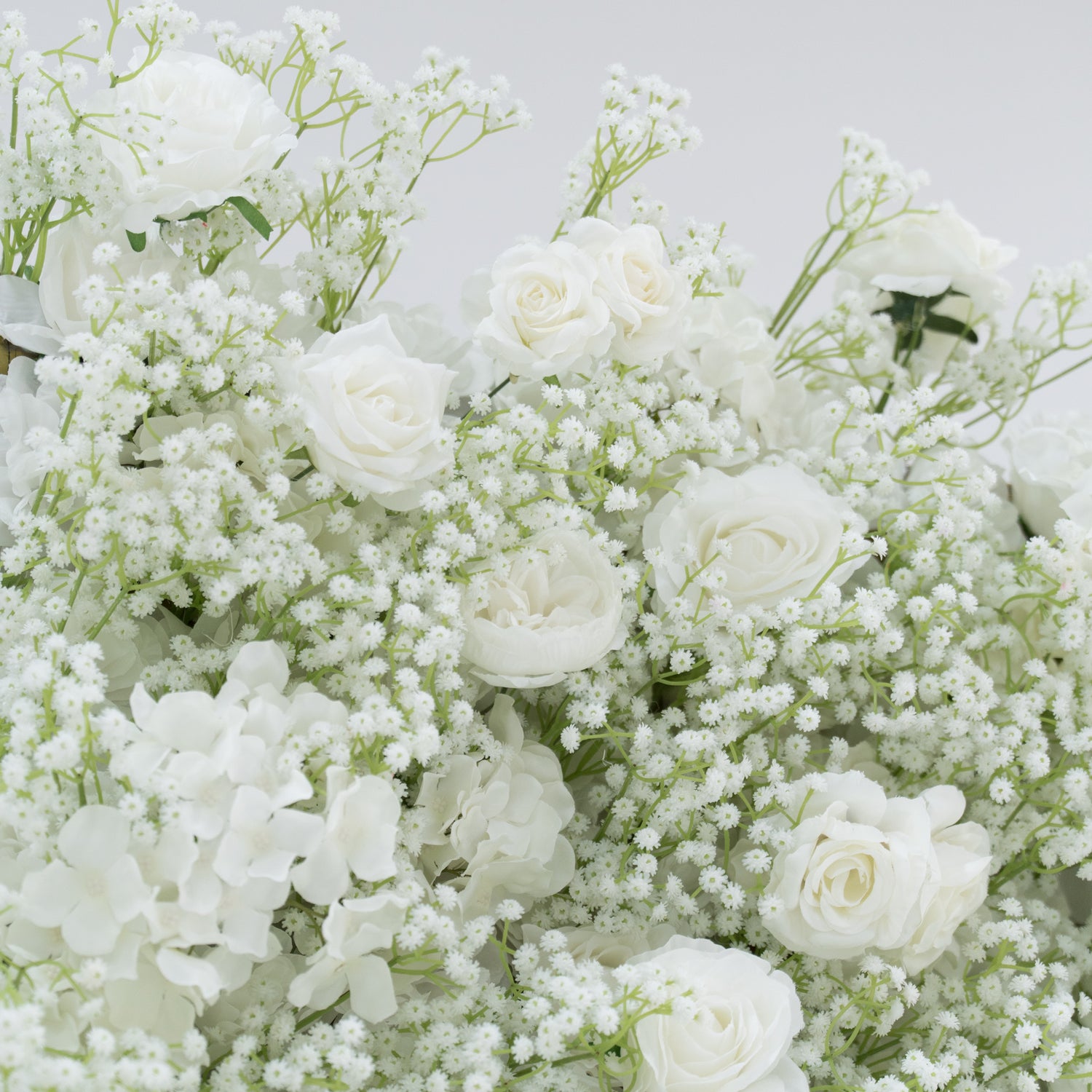 This image presents a lush arrangement of white flowers, including roses, hydrangeas, and baby&