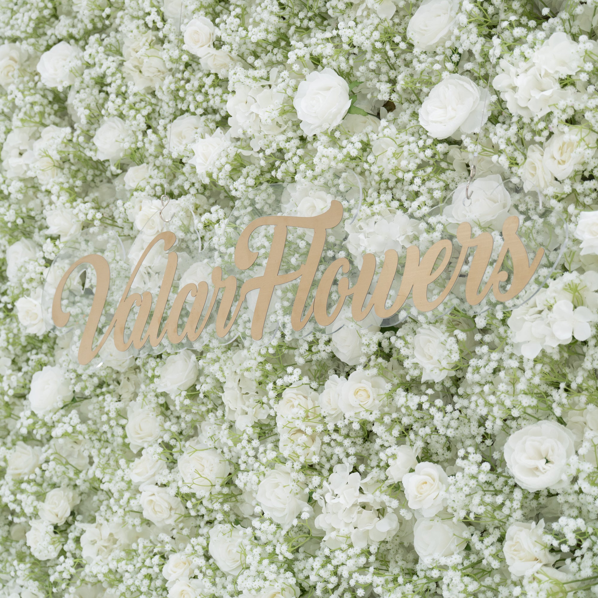 This image showcases a stunning floral wall by Valar Flowers, densely adorned with white roses and baby&