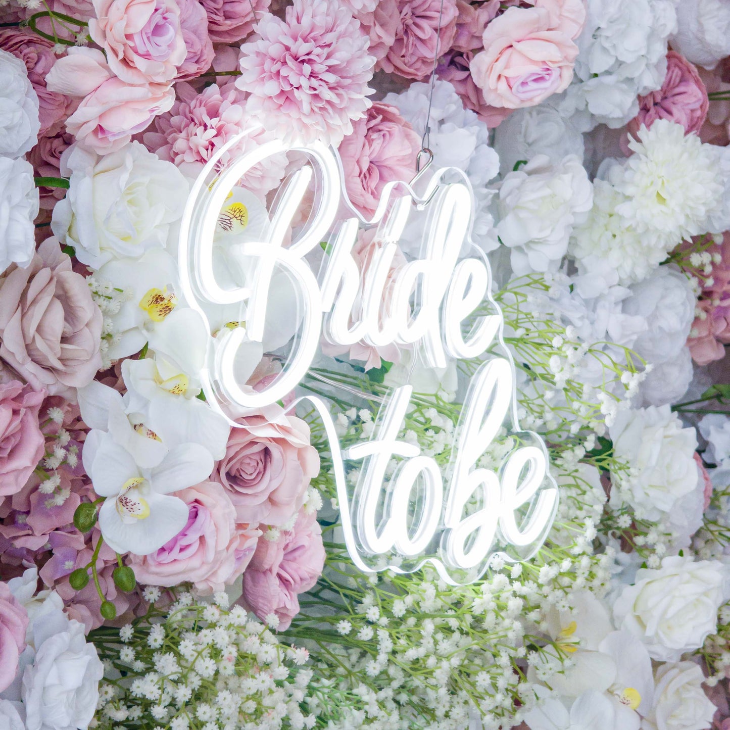 This backdrop is a lush floral arrangement with a romantic and feminine style. It features a mix of artificial flowers, including roses in soft pinks and whites, white orchids, and clusters of baby's breath. The color palette is pastel - toned, creating a gentle and elegant look. The "Bride to be" neon sign adds a celebratory touch, perfect for bridal events.