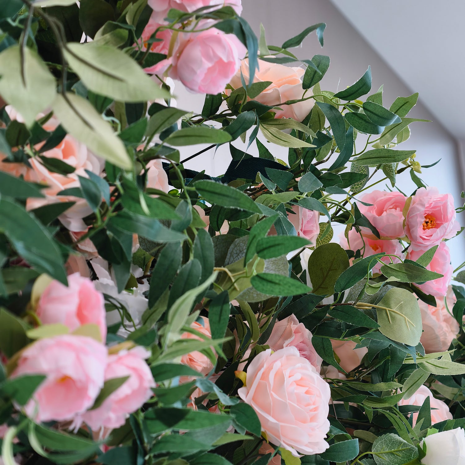 This photo showcases a lush arrangement of pink and light - peach roses intertwined with dense green foliage. The soft hues of the roses create a romantic and serene atmosphere. Ideal for events such as a "Sweet Blossom Birthday Bash" or a romantic anniversary celebration, it combines the elegance of roses with the freshness of greenery, making it a perfect decorative choice for intimate and refined occasions.