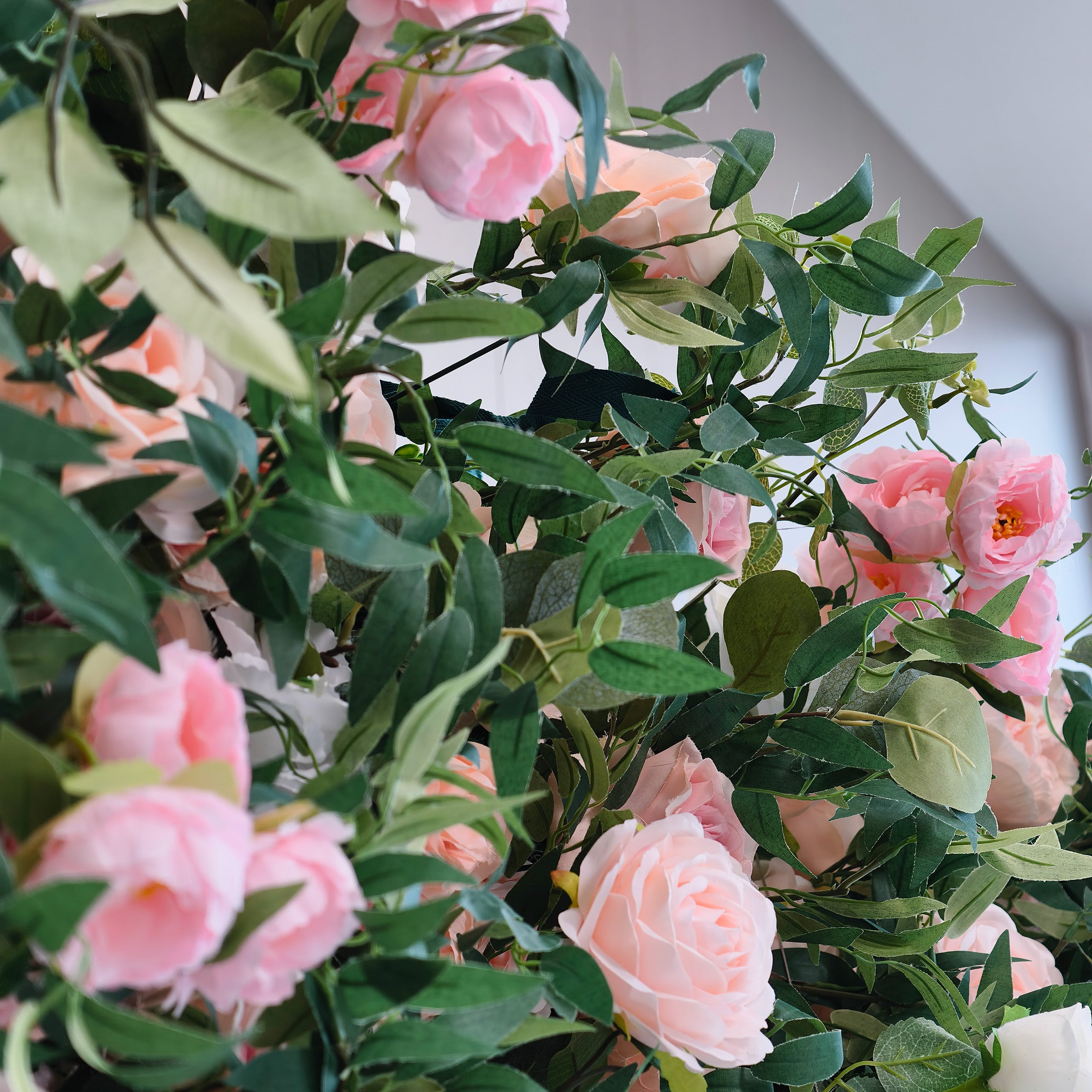 This photo showcases a lush arrangement of pink and light - peach roses intertwined with dense green foliage. The soft hues of the roses create a romantic and serene atmosphere. Ideal for events such as a "Sweet Blossom Birthday Bash" or a romantic anniversary celebration, it combines the elegance of roses with the freshness of greenery, making it a perfect decorative choice for intimate and refined occasions.