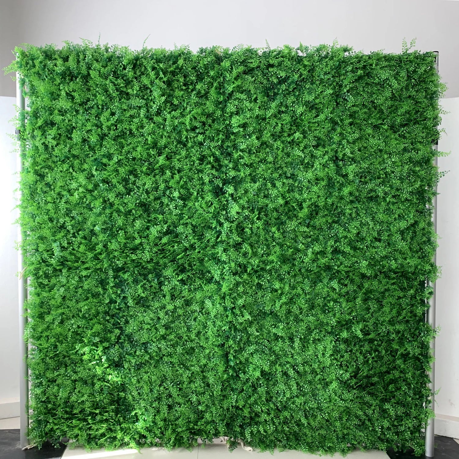 This image showcases a dense, lush expanse of artificial greenery. It features a rich tapestry of small, varied green leaves and foliage, creating a textured, natural-looking display. The vibrant green hues and intricate plant details give it a realistic, refreshing appearance, ideal for use as a backdrop or decor element to bring an organic, serene atmosphere to spaces or events.