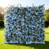 This image features a large floral wall outdoors on a lush green lawn. It&