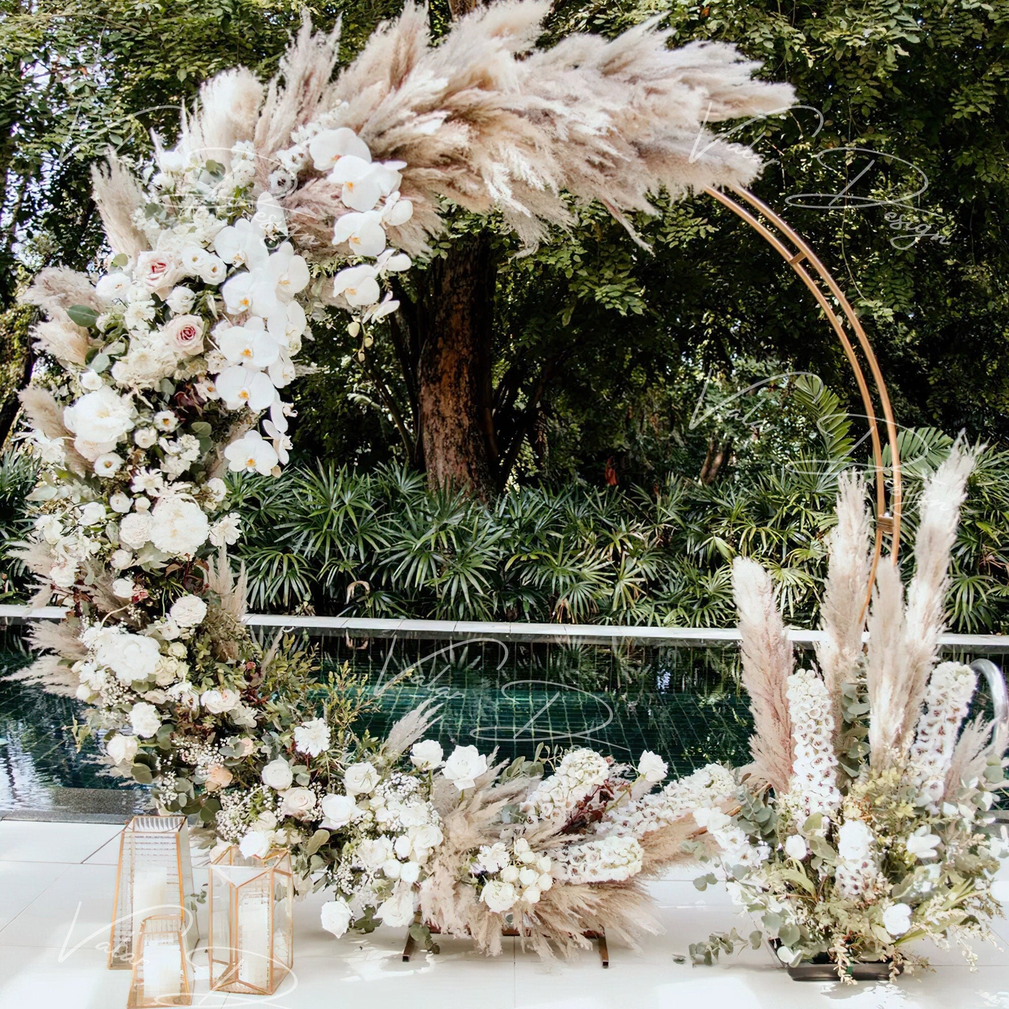 This backdrop features a floral arch with white orchids, roses, and hydrangeas, paired with beige pampas grass. Set outdoors by a pool with greenery, it blends elegant white blooms and natural textures for a romantic, refined style.